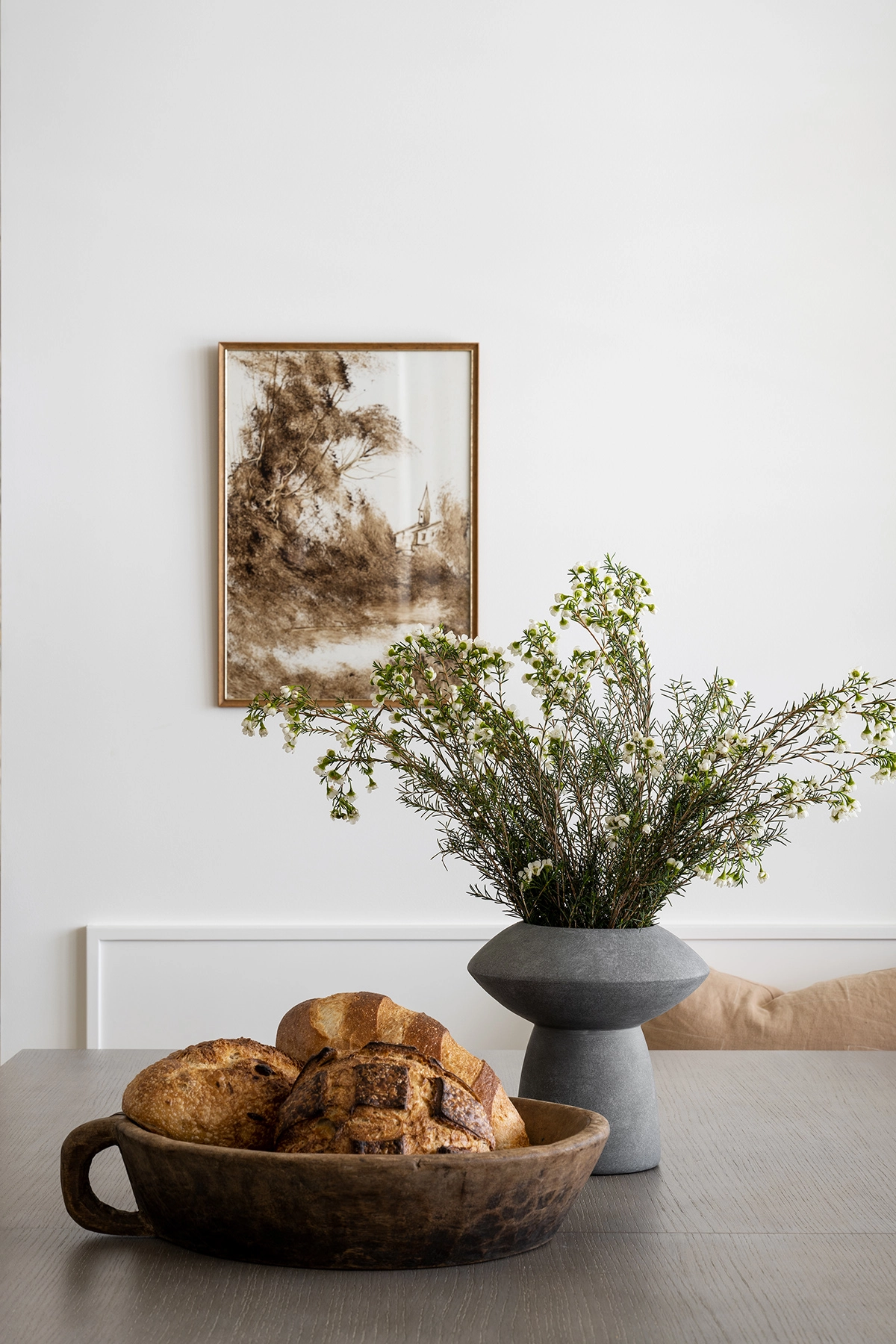 dining nook with bread basket and vase with greenery