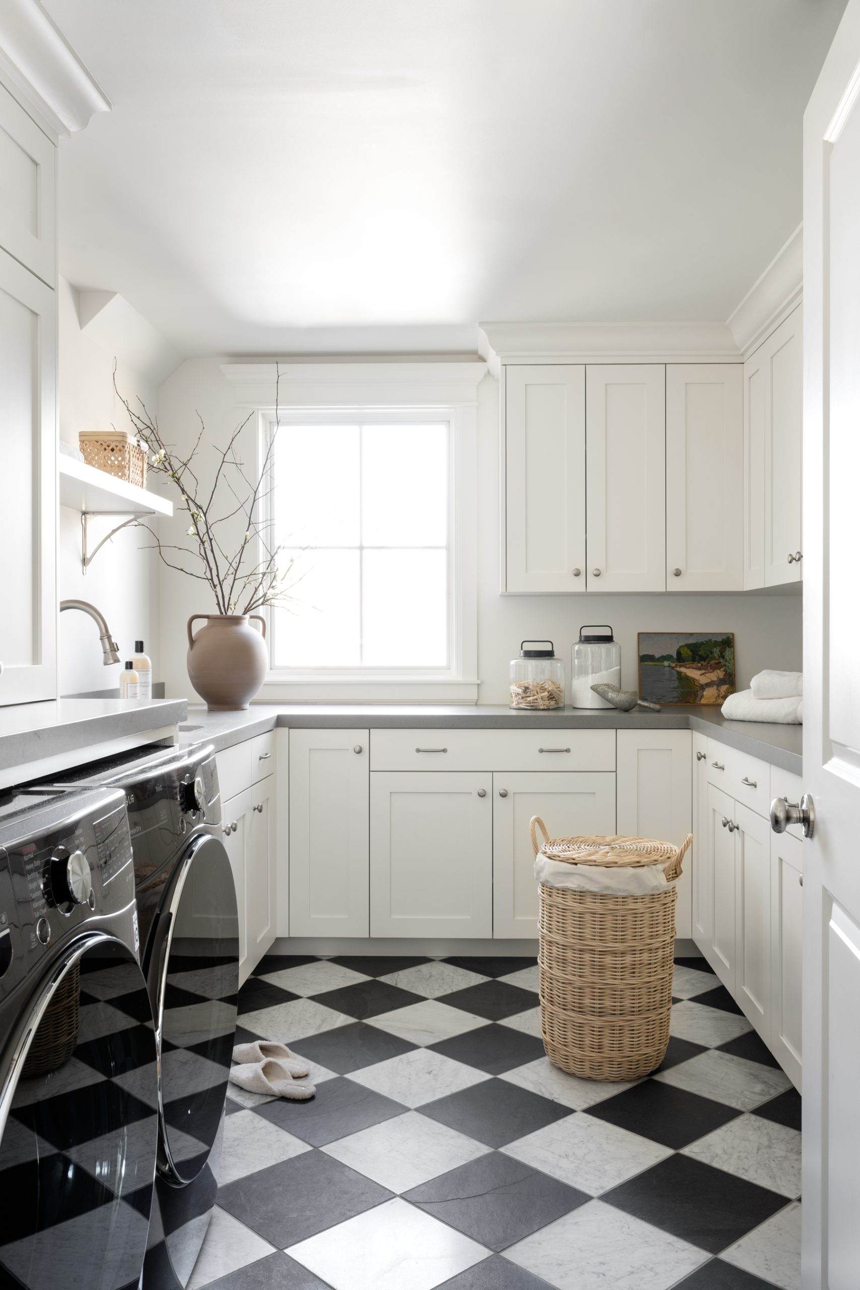 laundry room with black and white checkered floor and white cabinetry