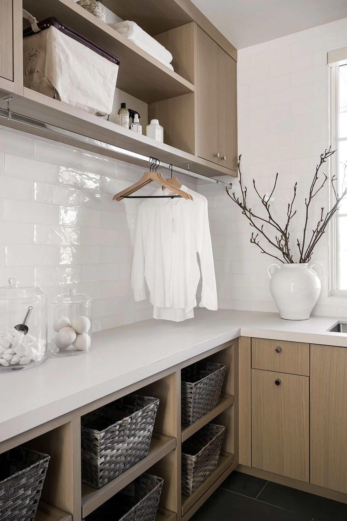laundry room with natural wood cabinetry and storage baskets