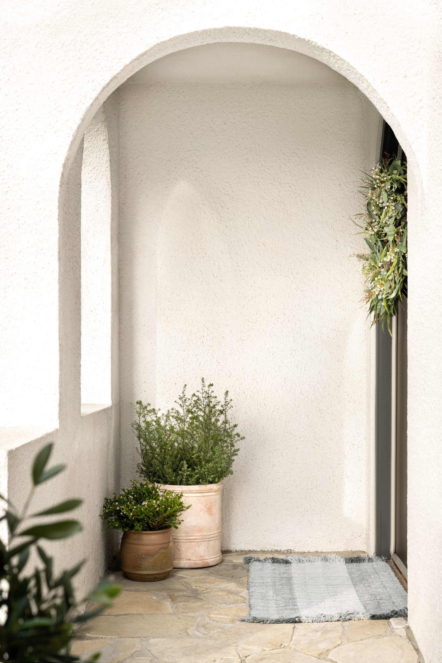 doormat in front of door with planters