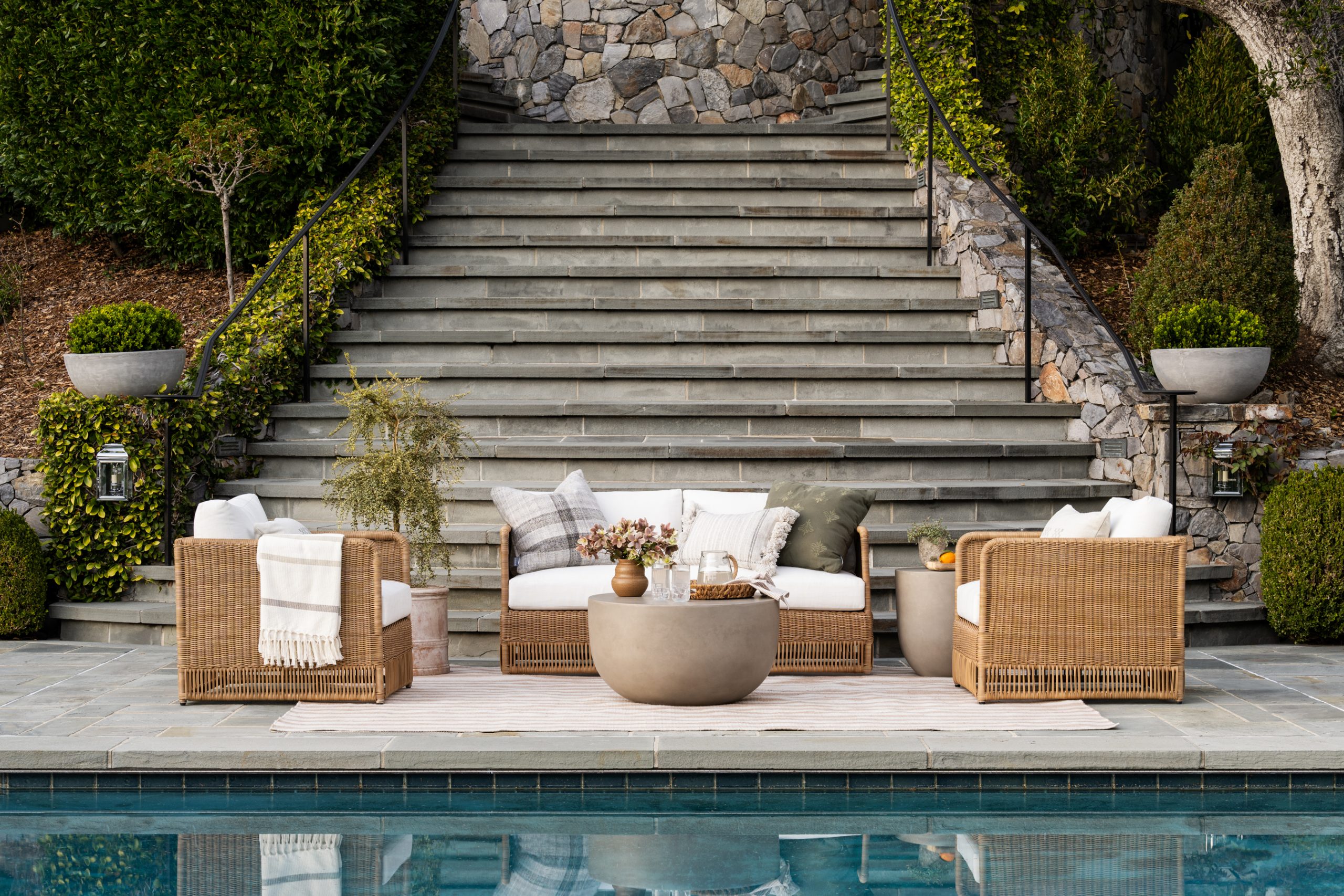 wicker lounge chair and sofa around coffee table by pool