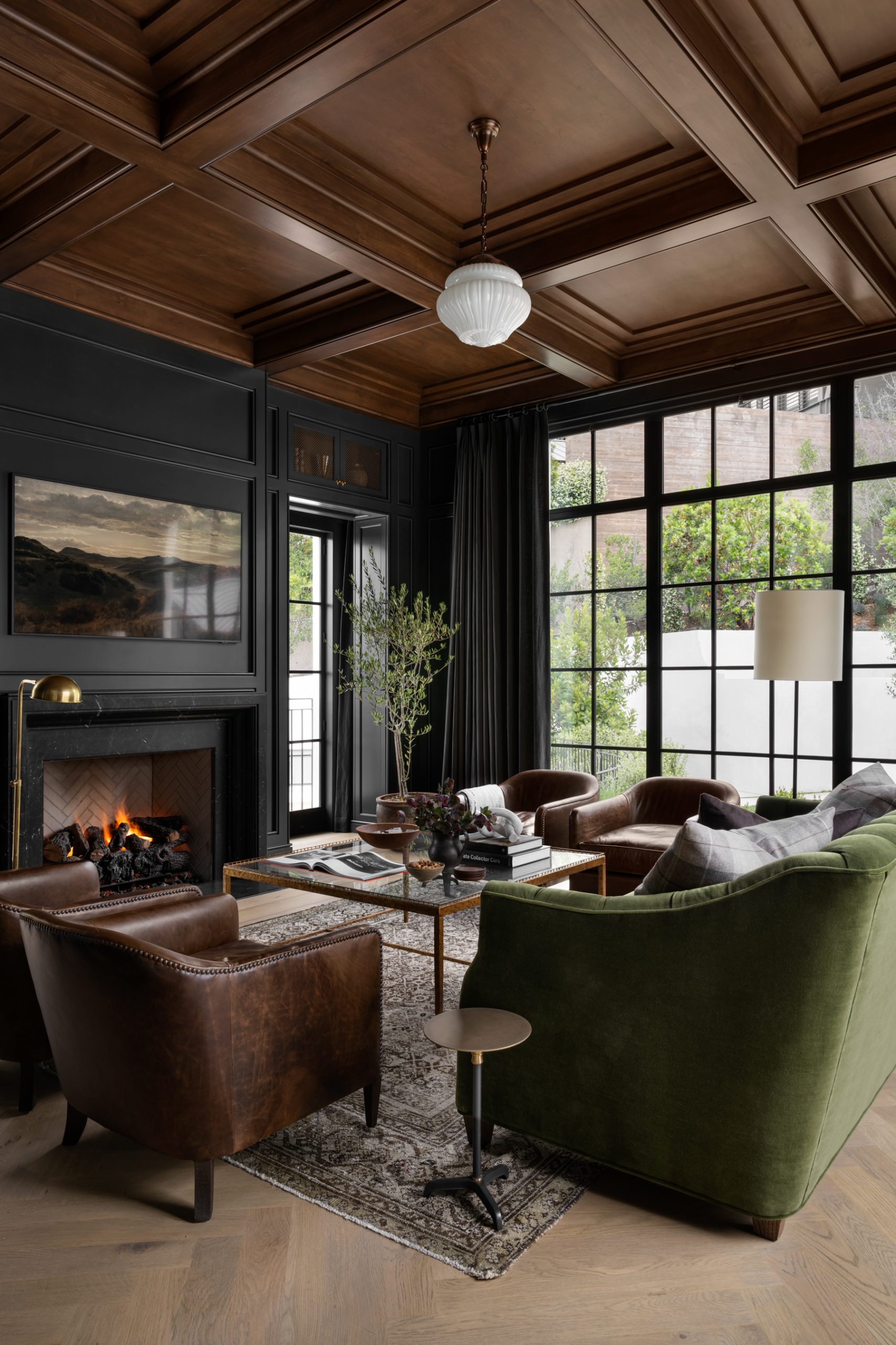 Living room with dark blue walls and dark wood ceiling with fireplace
