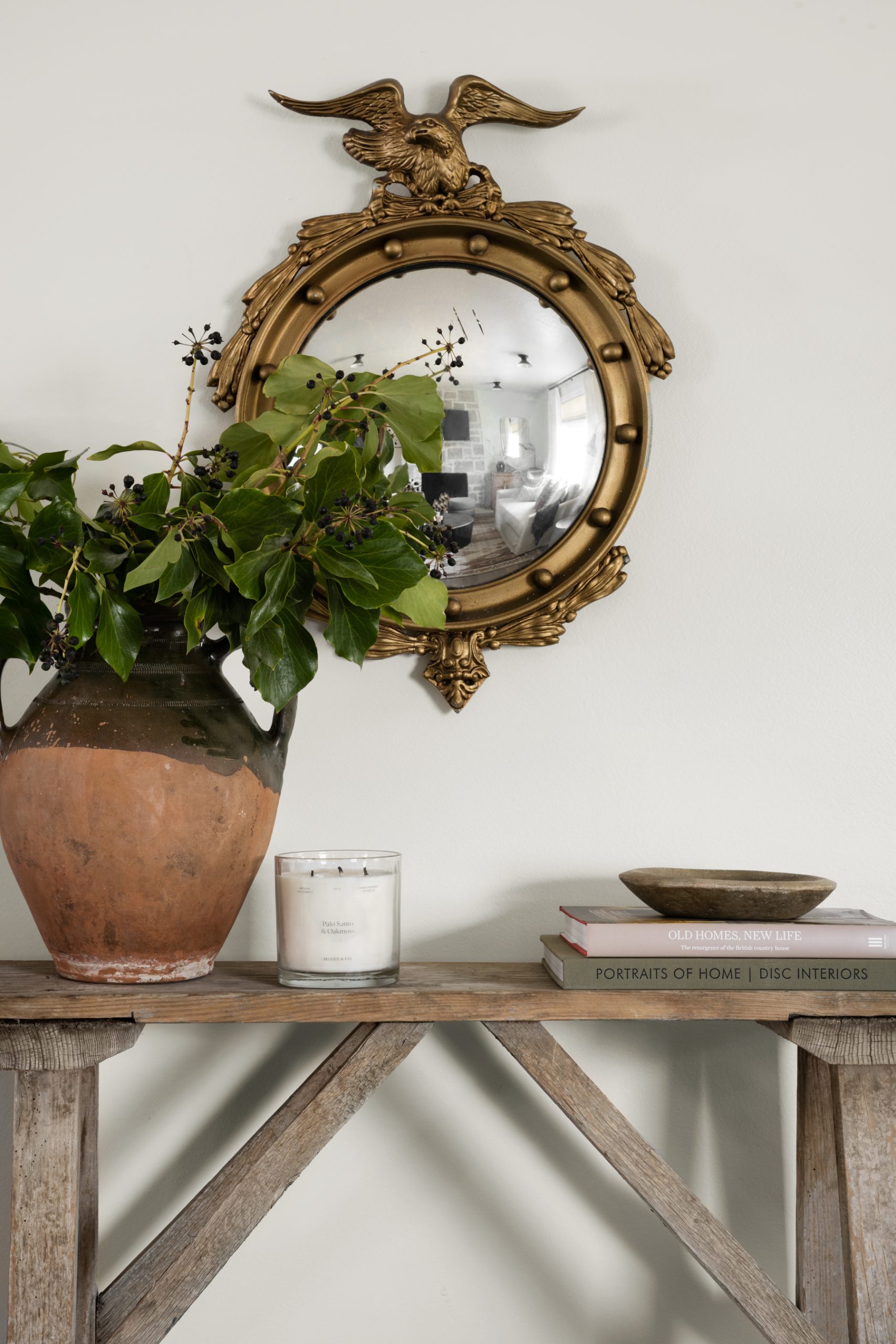 eagle convex mirror above wood console table