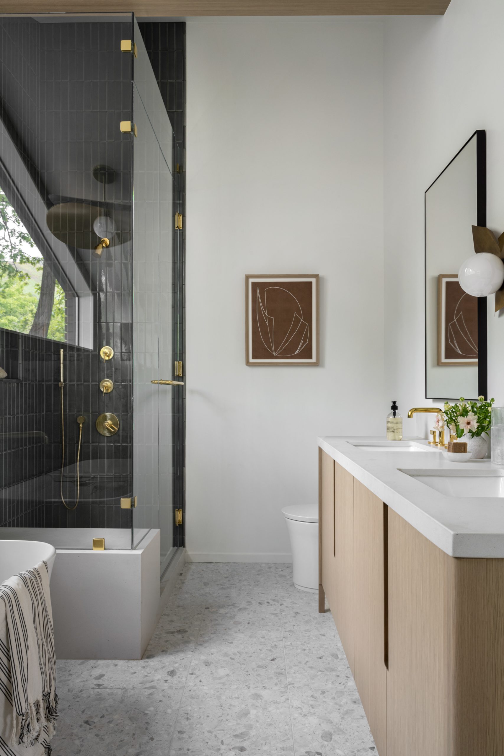 midcentury bathroom with green tile in shower and wood cabinets