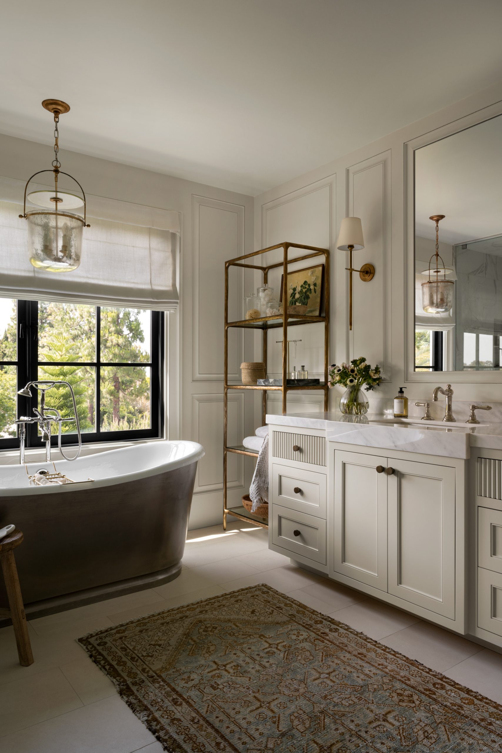 bathroom with cream cabinets and marble counter top and dark standing bathtub