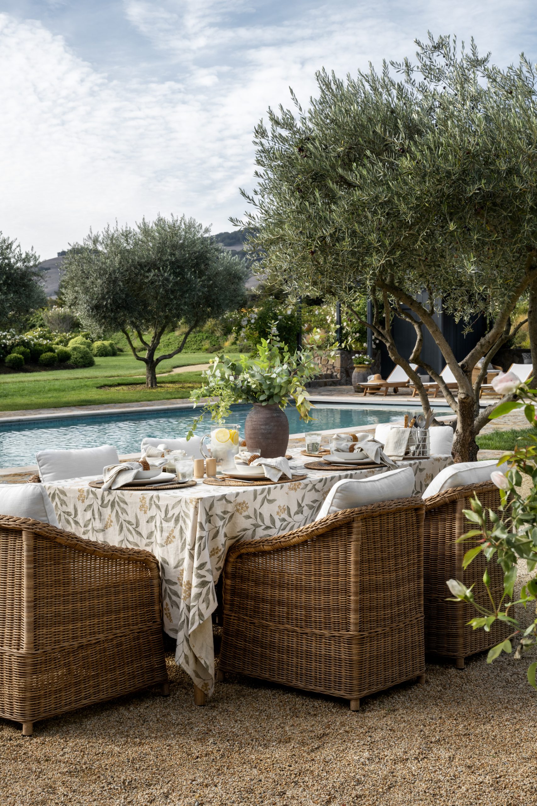 wicker outdoor dining chair around poolside tablescape