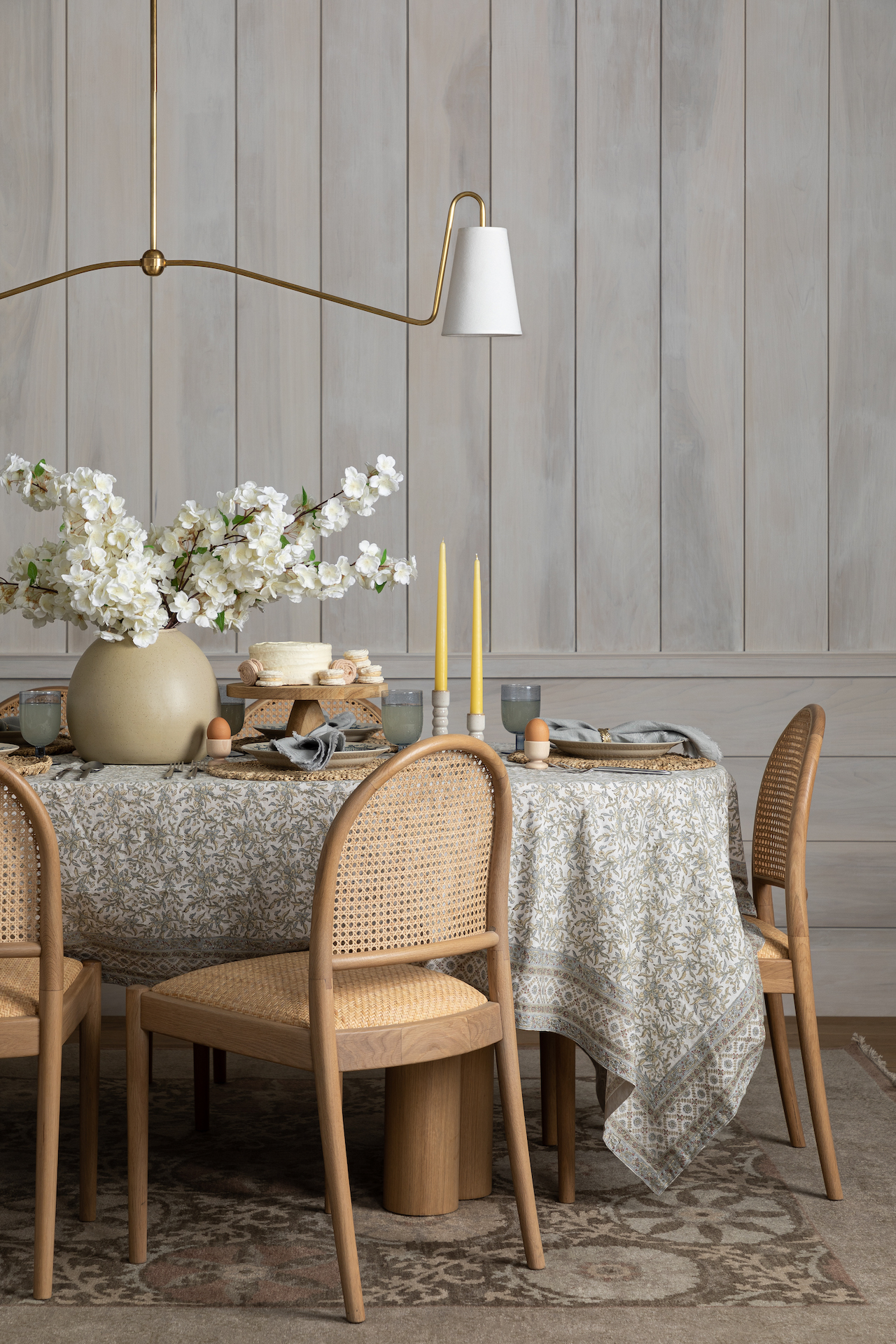 Easter tablescape with light wood chairs and blue floral tablecloth