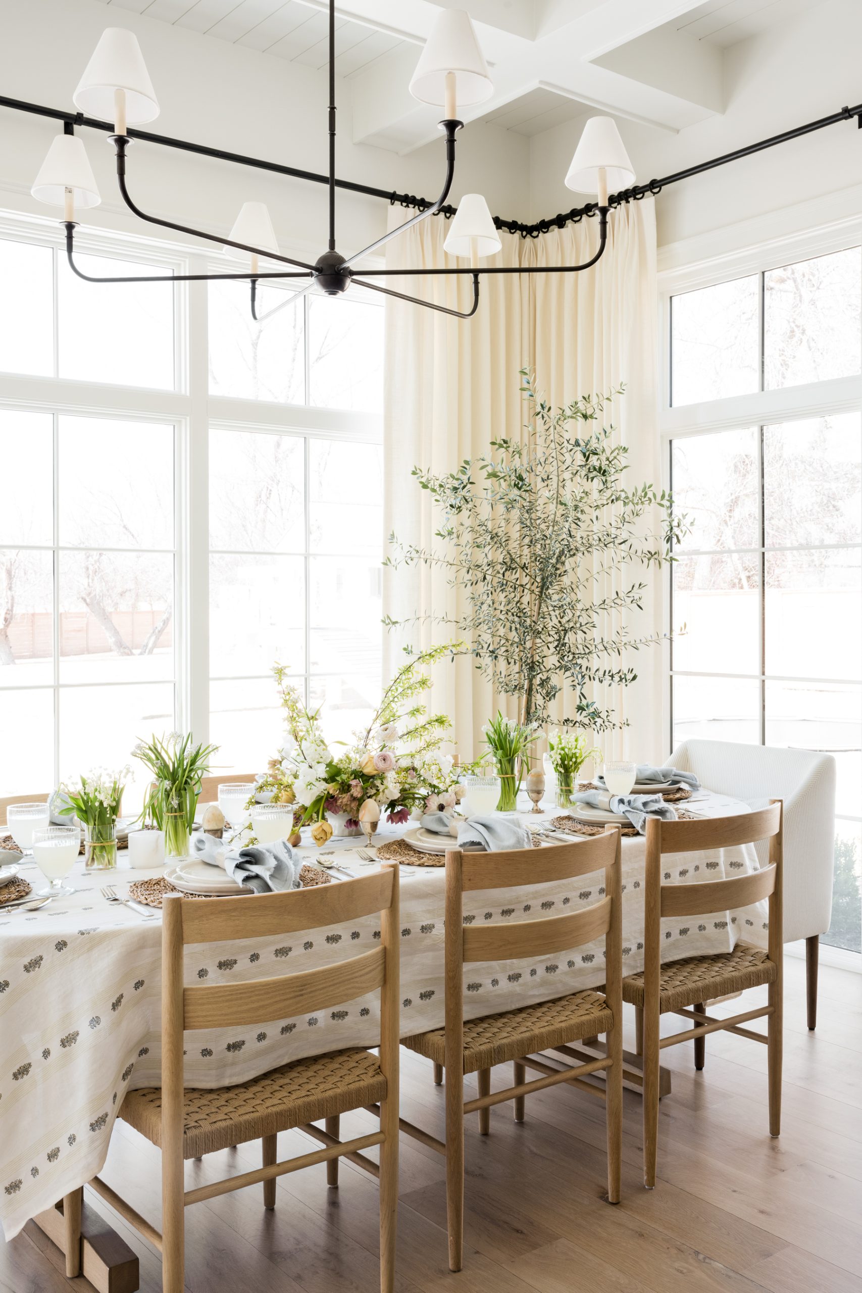 Easter tablescape with tan floral tablecloth and wood chairs
