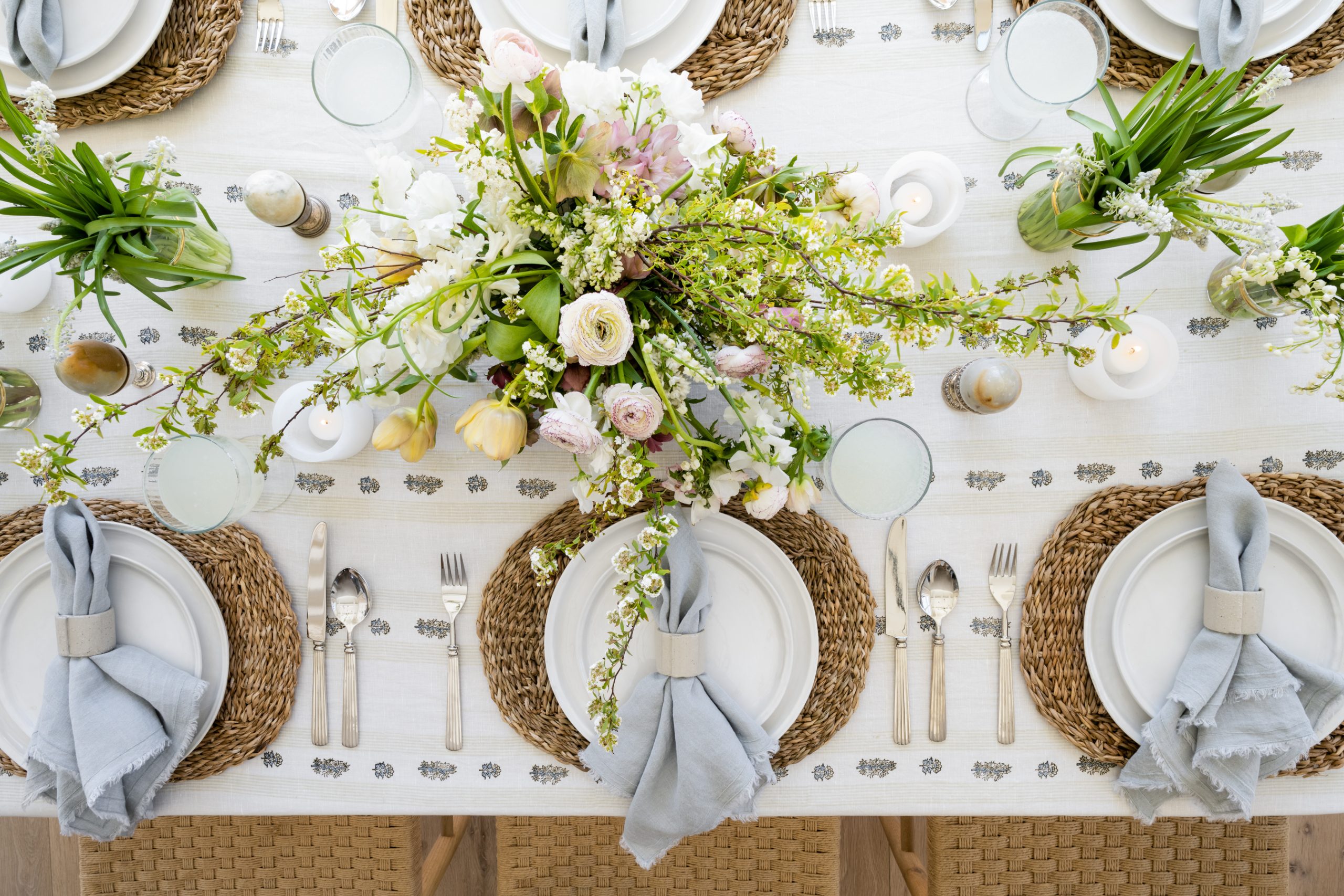 Easter tablescape with tan floral tablecloth and wood chairs