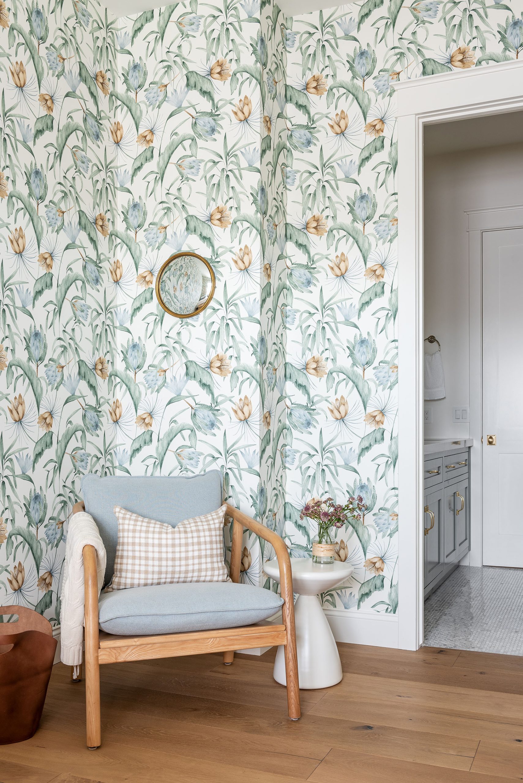bedroom with floral wallpaper with chair and side table in corner