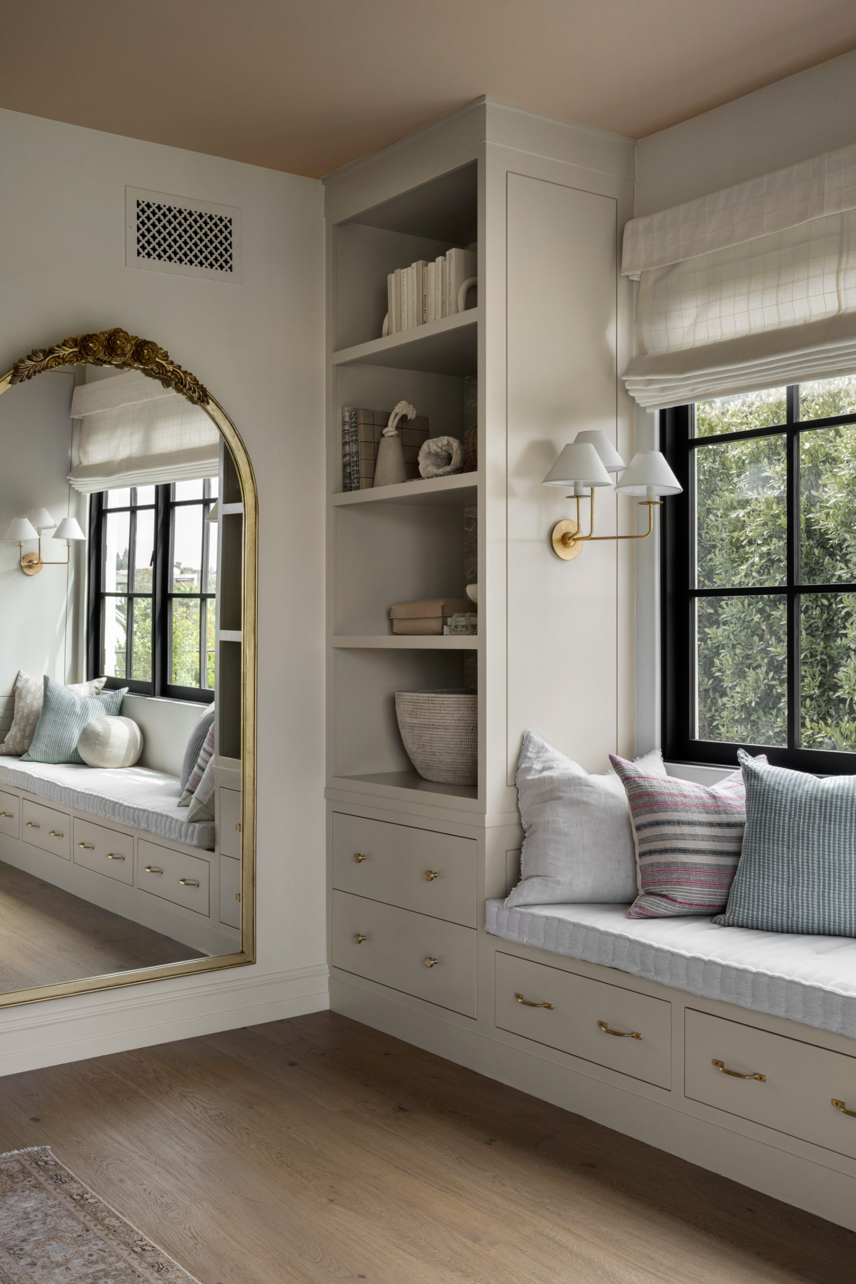 bedroom with built-in cabinets window seat and floor mirror