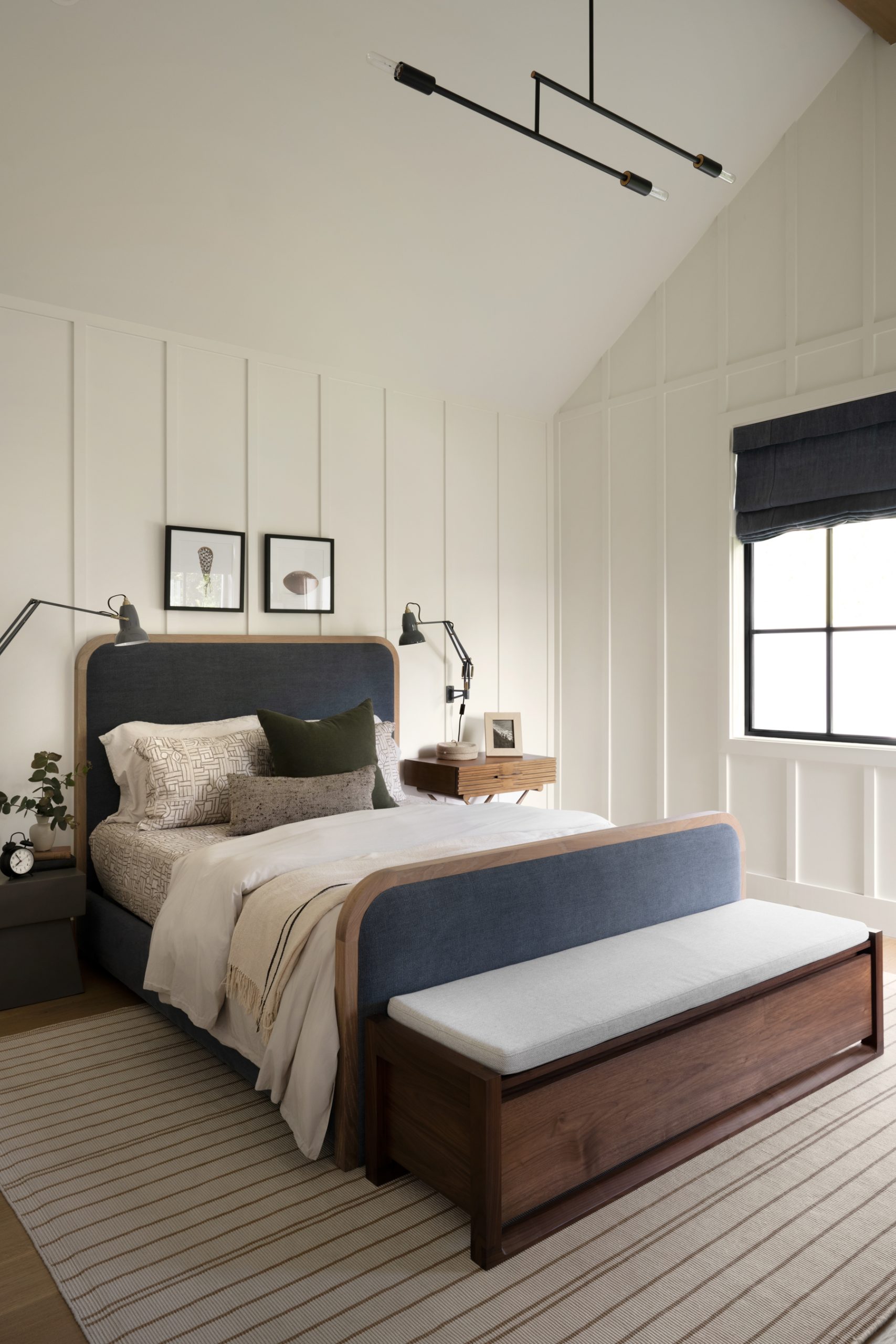 bedroom with white panelling with blue upholstered bed