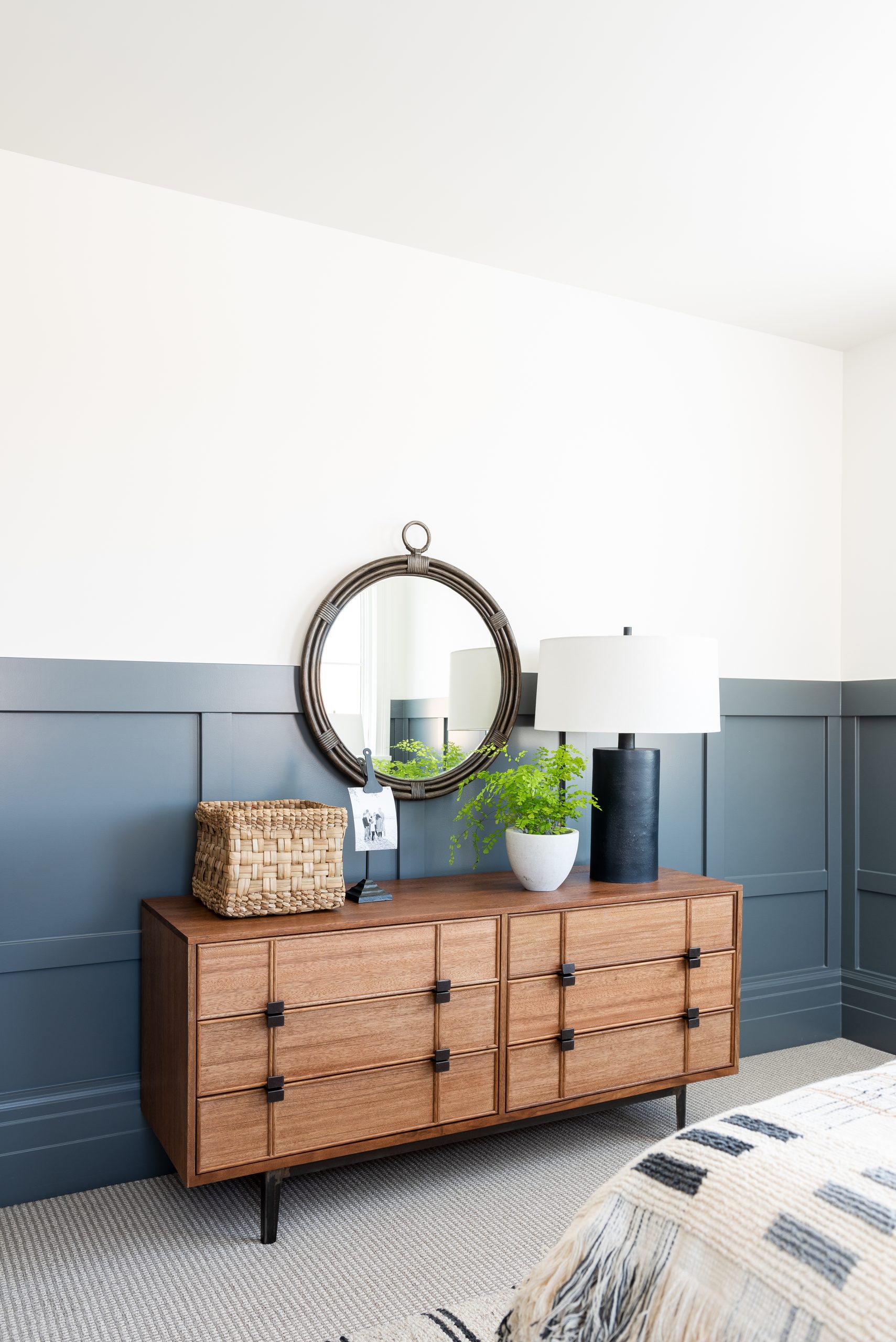 bedroom with blue paneling and dark wood dresser