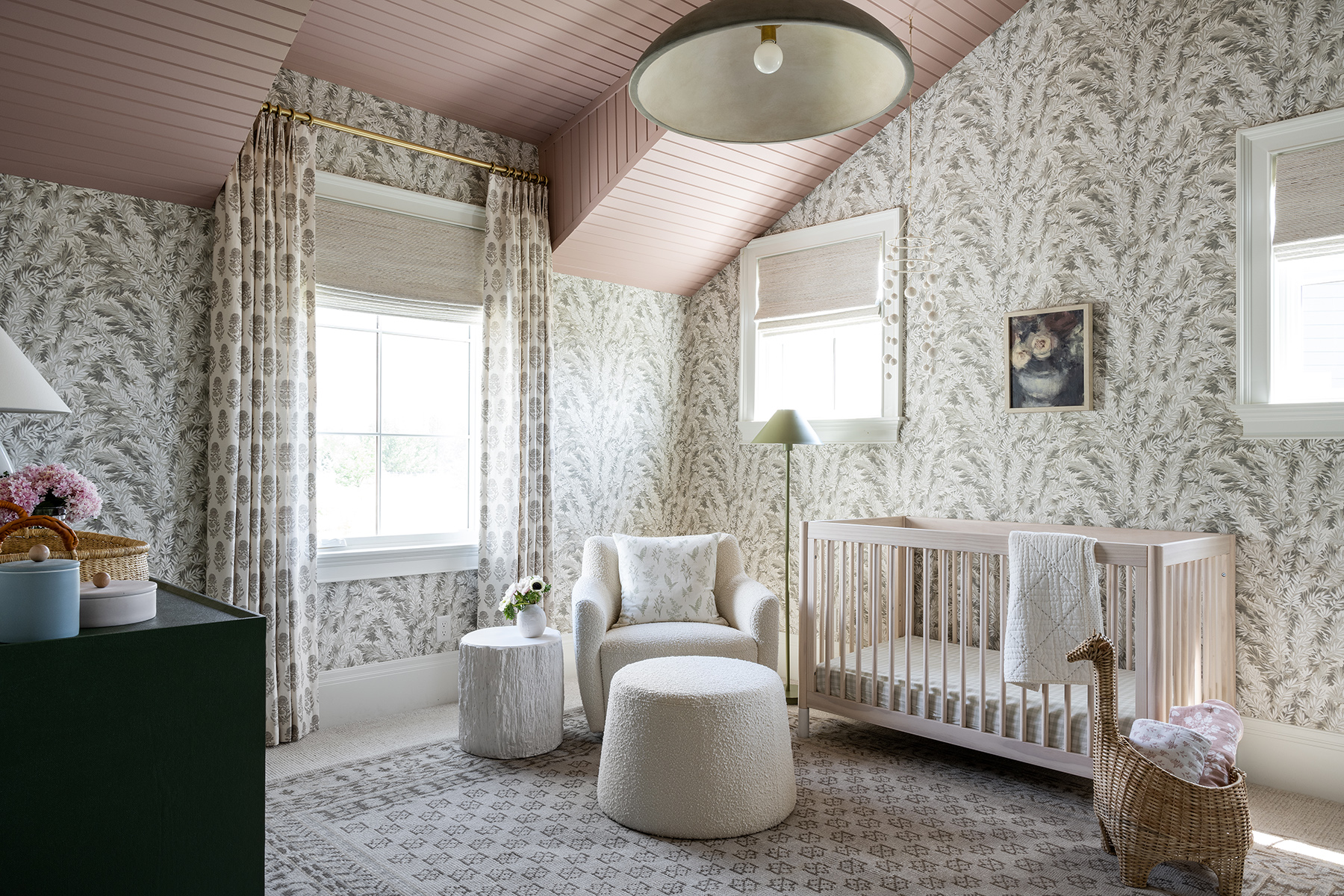 nursery with floral wallpaper and pink ceiling with floral drapes and geometrical patterned rug