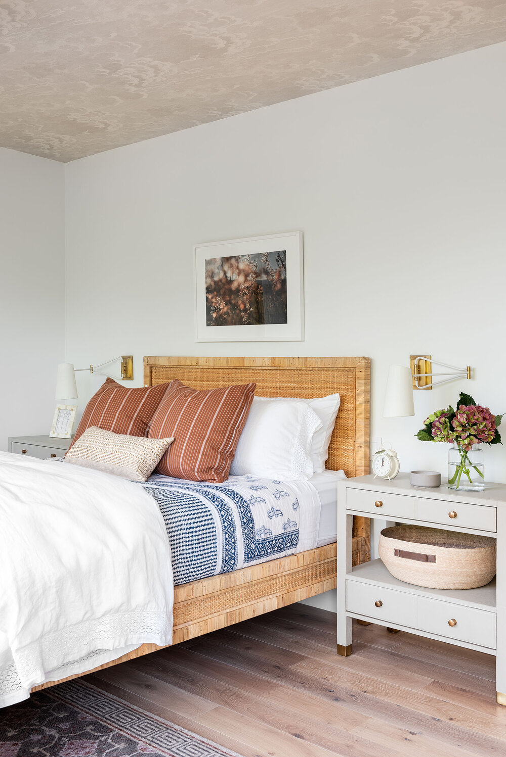 bedroom with natural wood bed frame and white nightstands