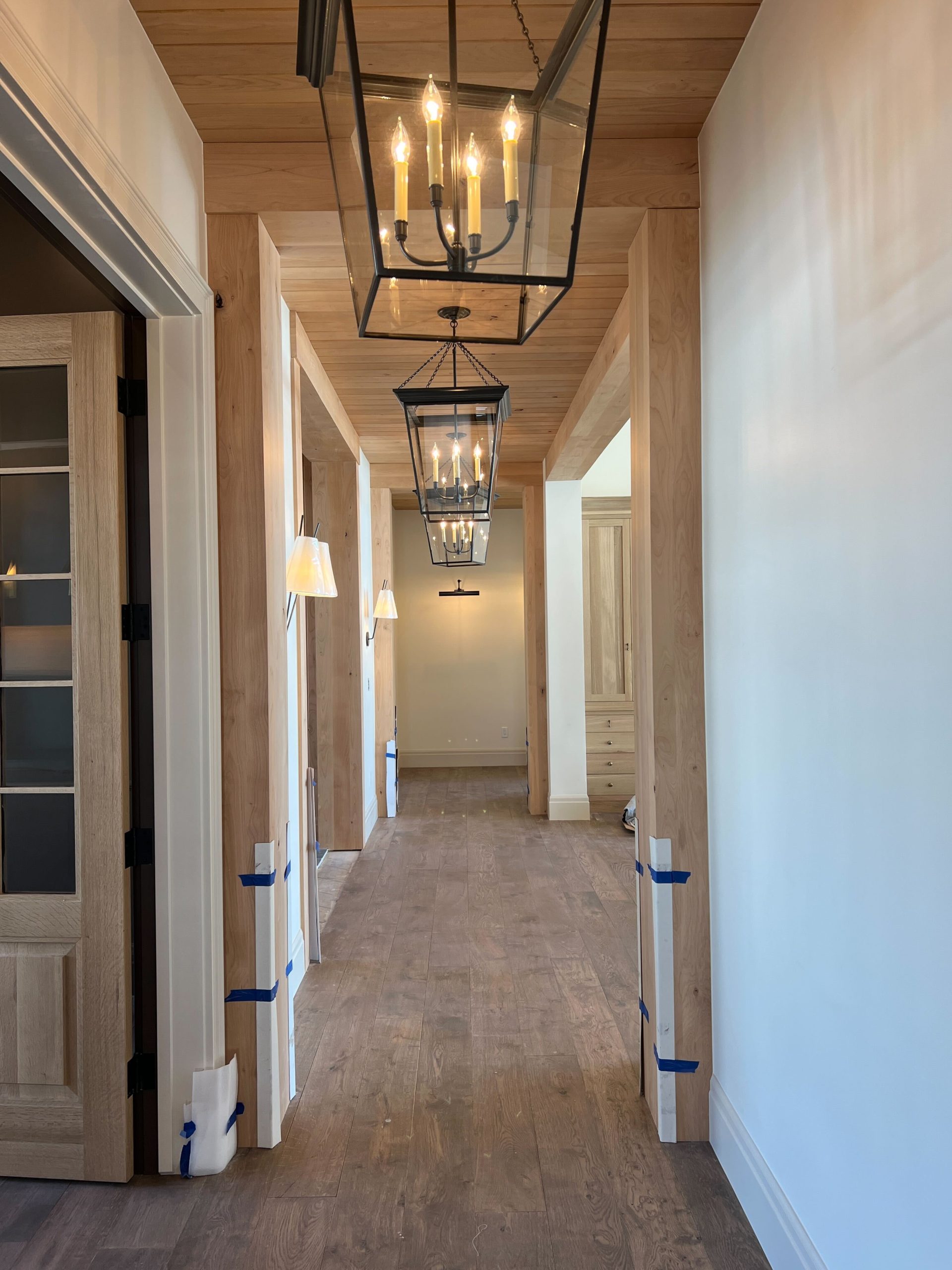 hallway with repeating lights and wood floor