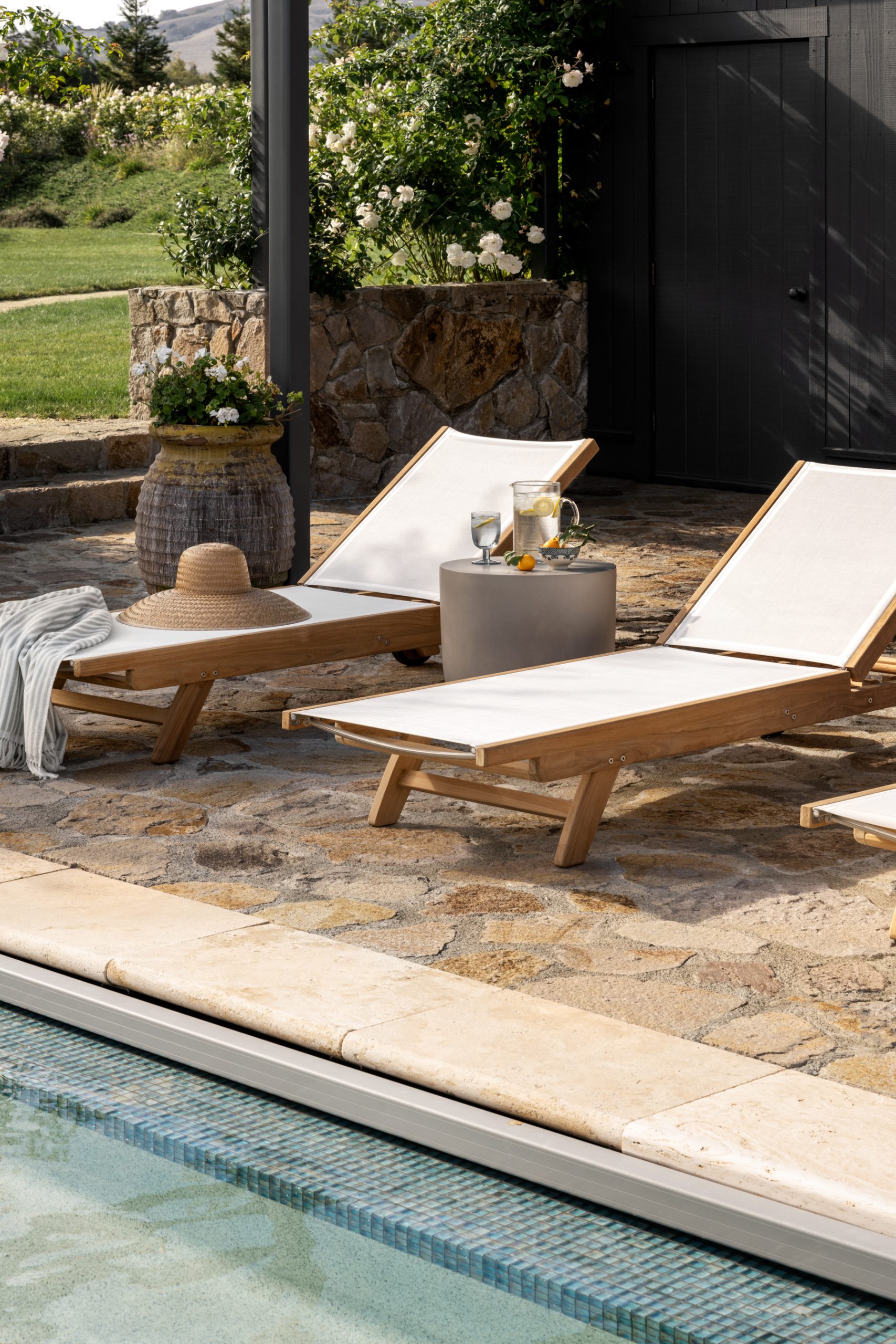Teak outdoor chaise lounge chairs by the pool