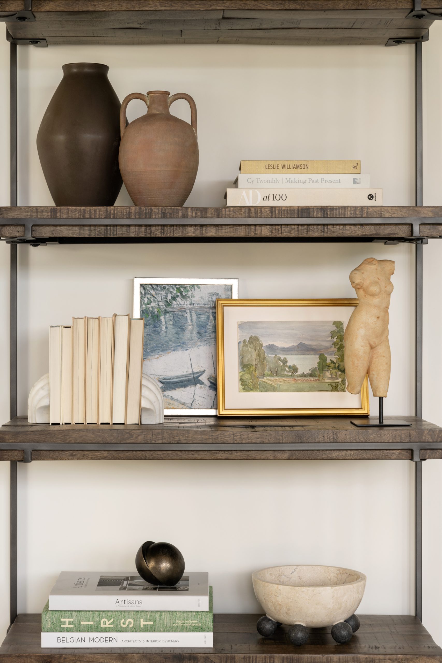book shelf with decorative objects with green book and green landscape artwork