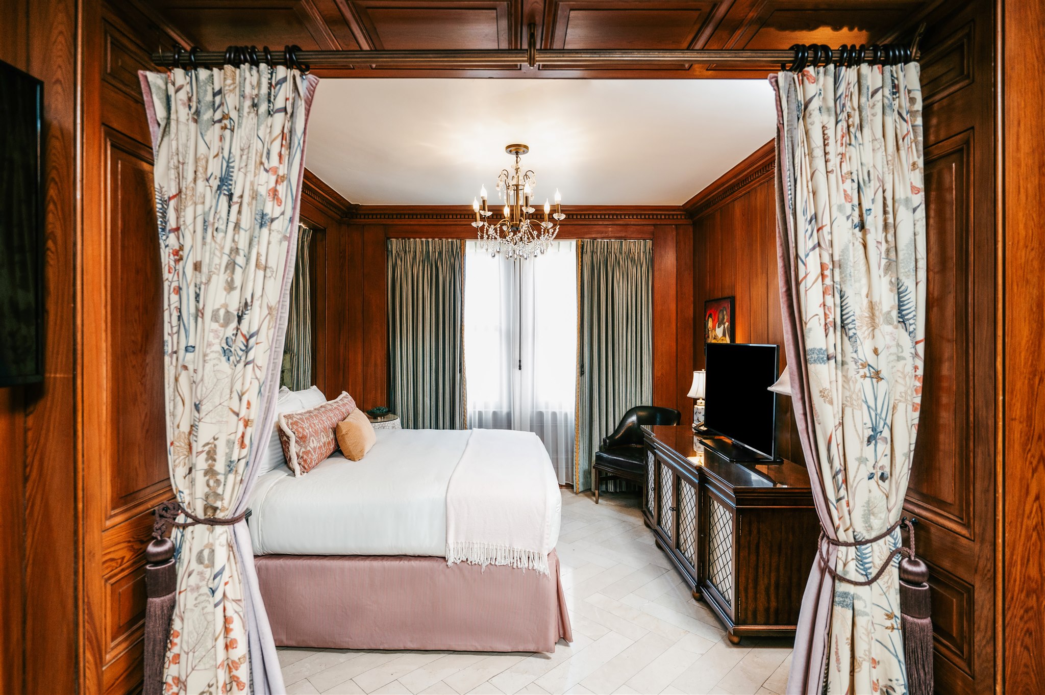 Pontchartrain Hotel guest room with wood panelling and patterned curtains