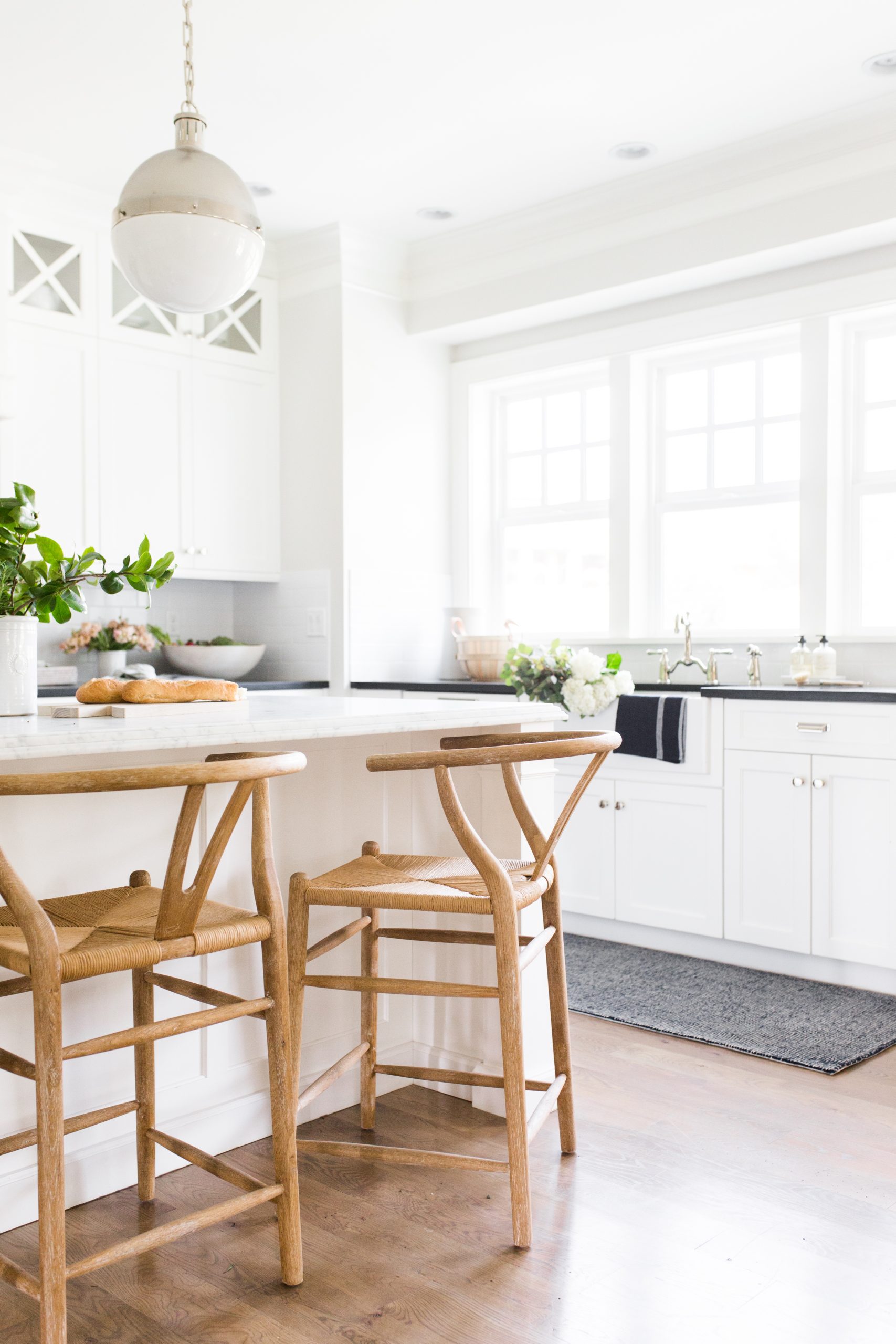 white kitchen with white cabinets and natural wood stools