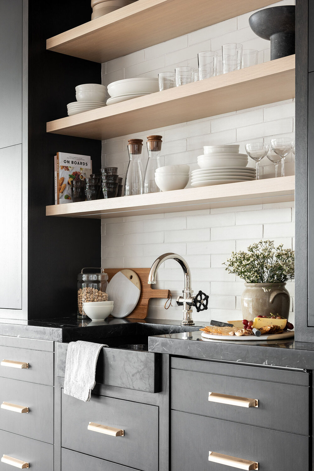 kitchenette with dark cabinets and white oak floating shelves