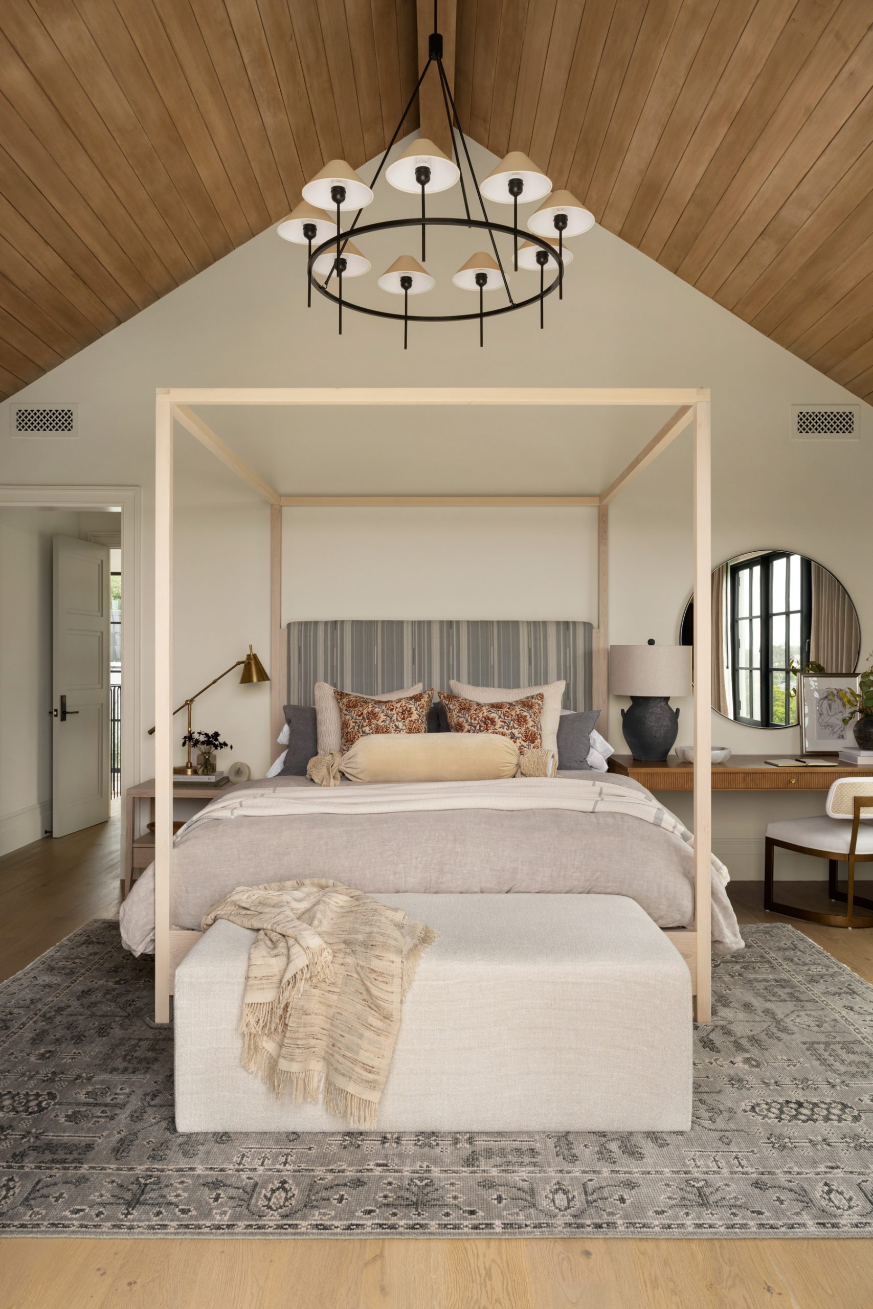 canopy bed with bench at end of bed and circular light fixture