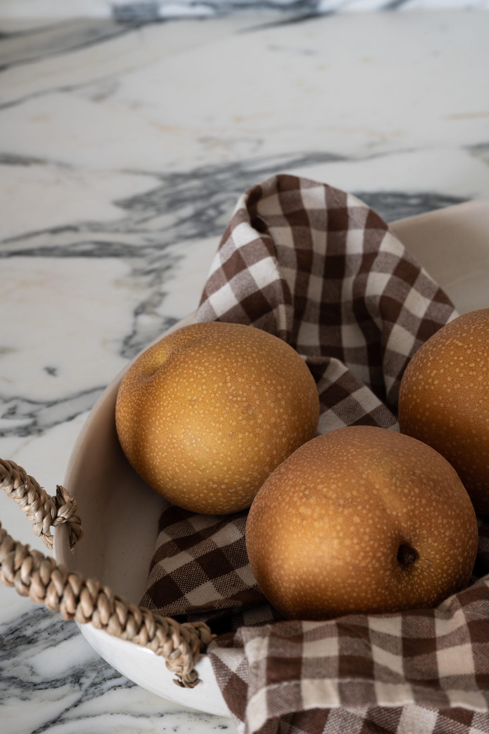 asian pears in tray on marble countertop