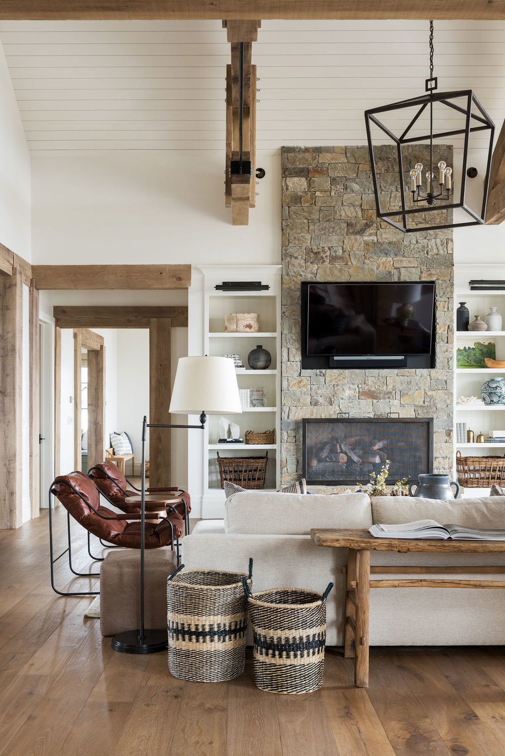 Living room with stone fireplace with sofa and leather chairs