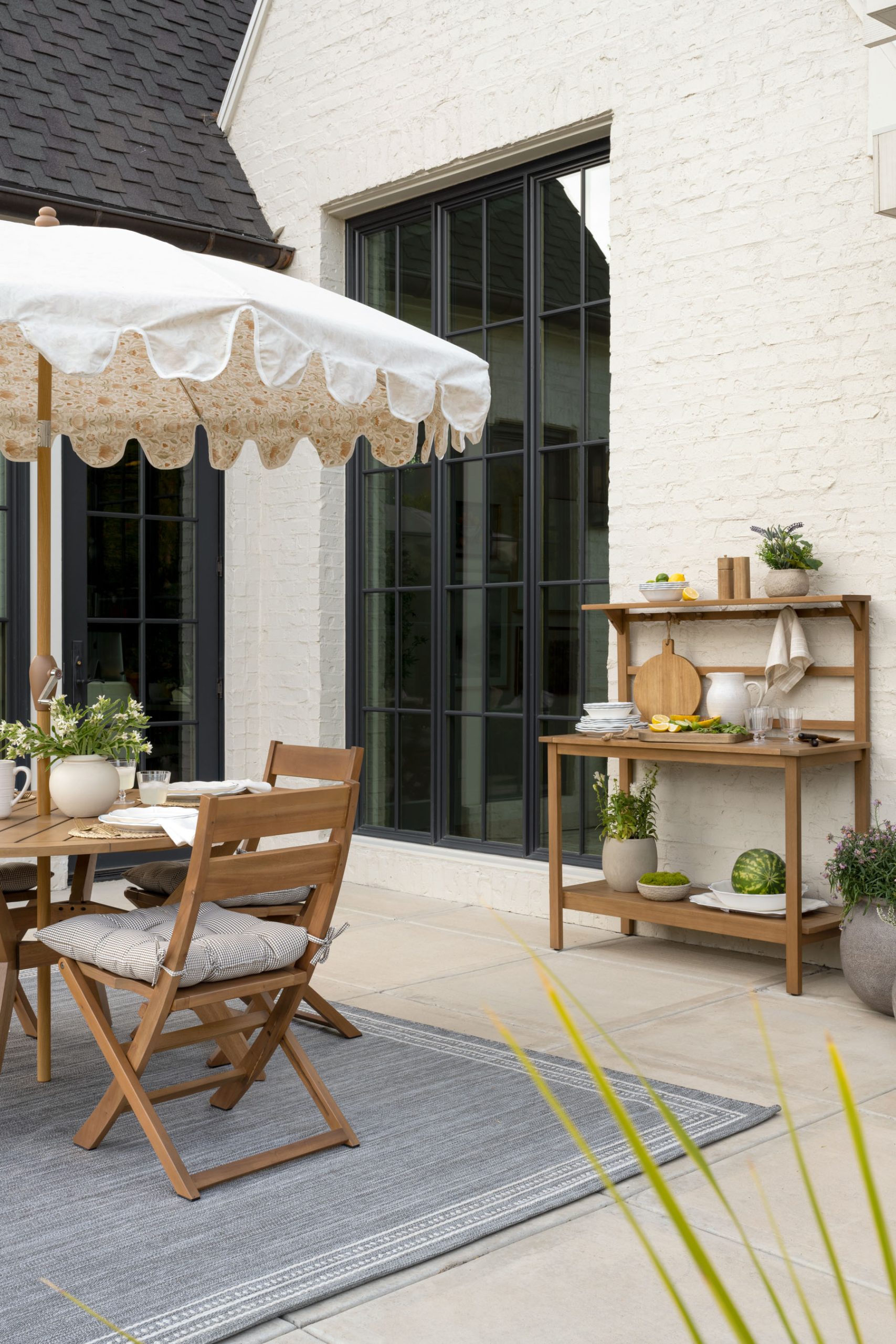 Outdoor dining area with umbrella and wood hutch