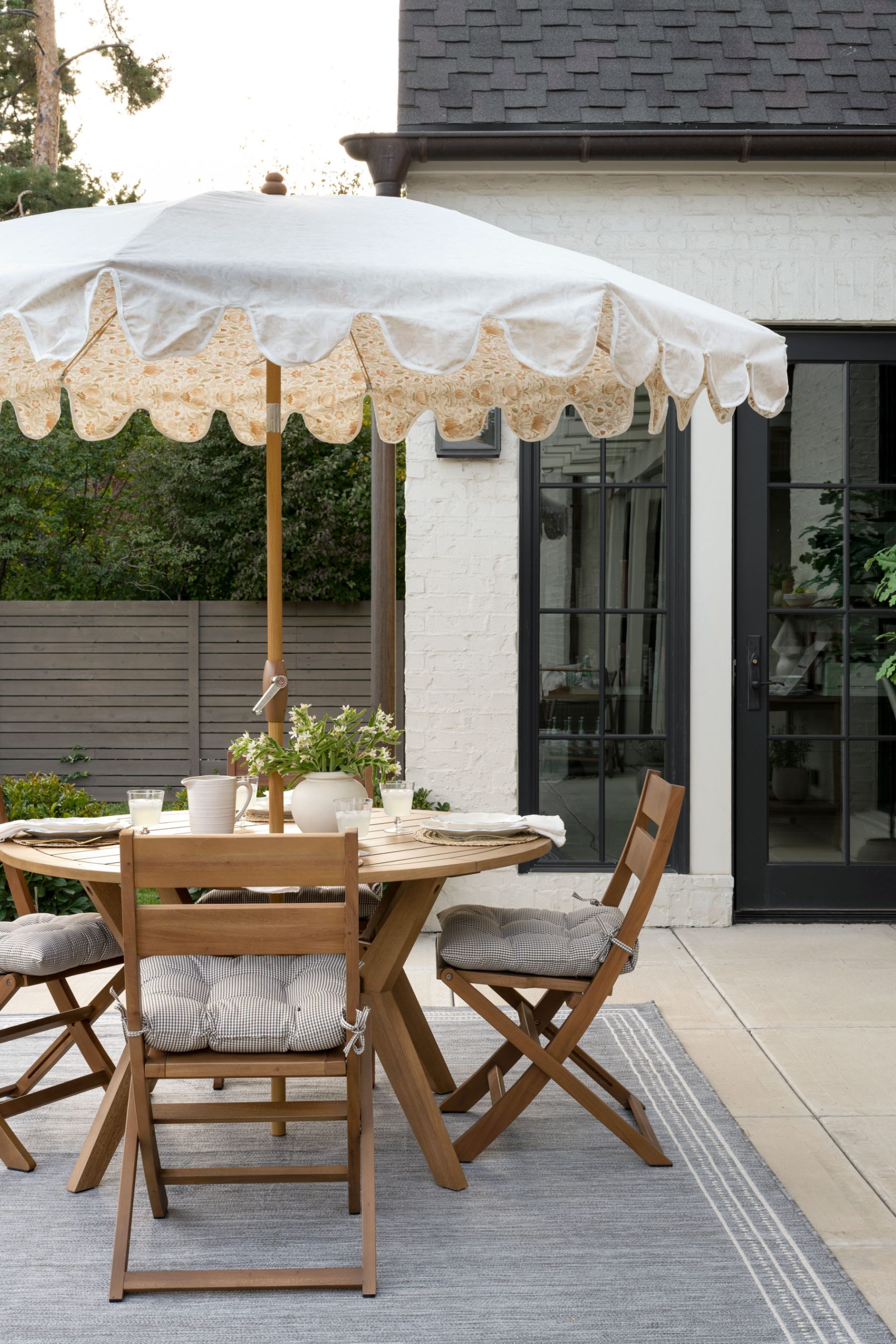 Outdoor dining table with folding chairs and umbrella