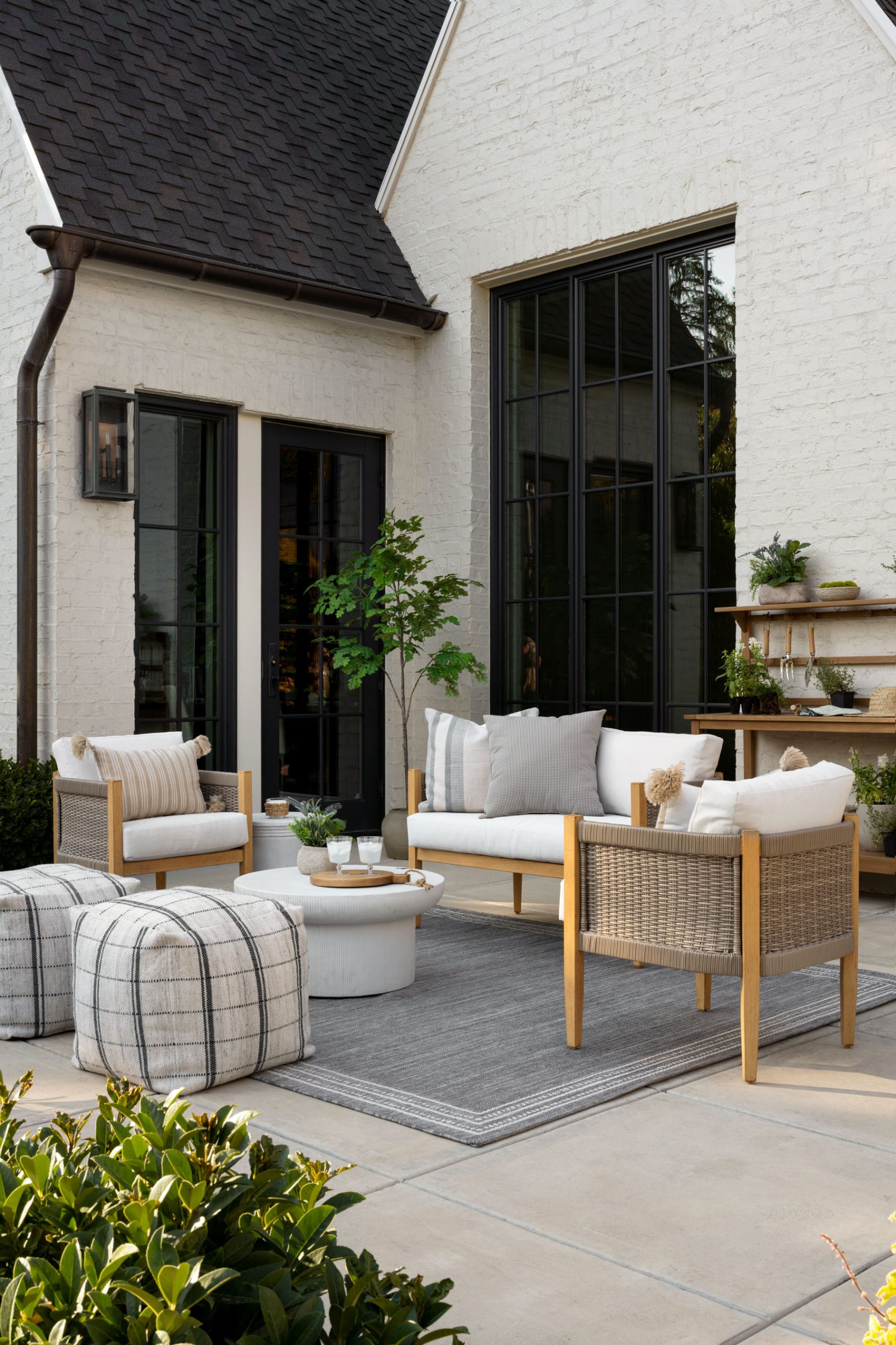 Outdoor living area with sofa and chairs and round table with ottomans