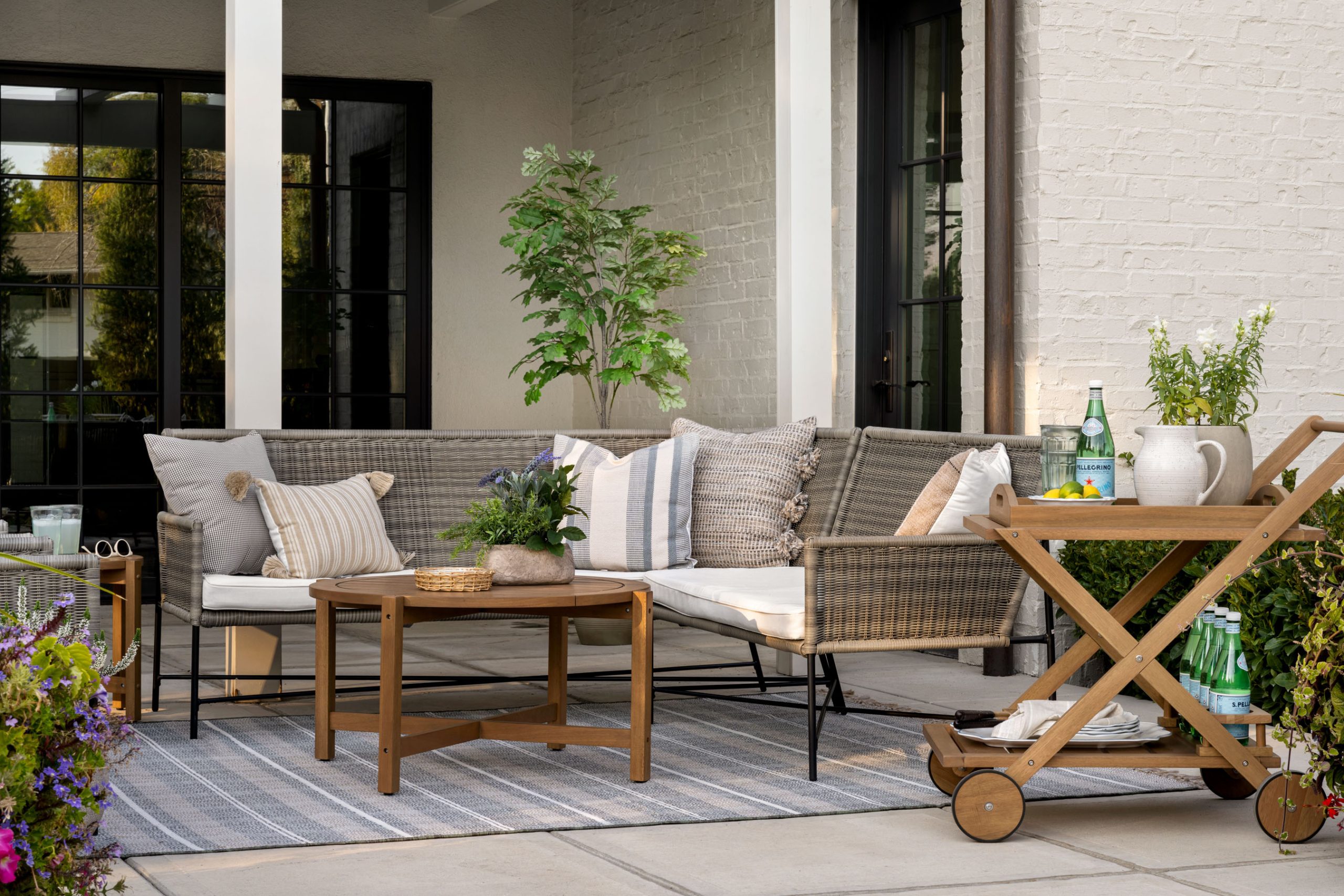 Outdoor living area with woven sectional and wood bar cart