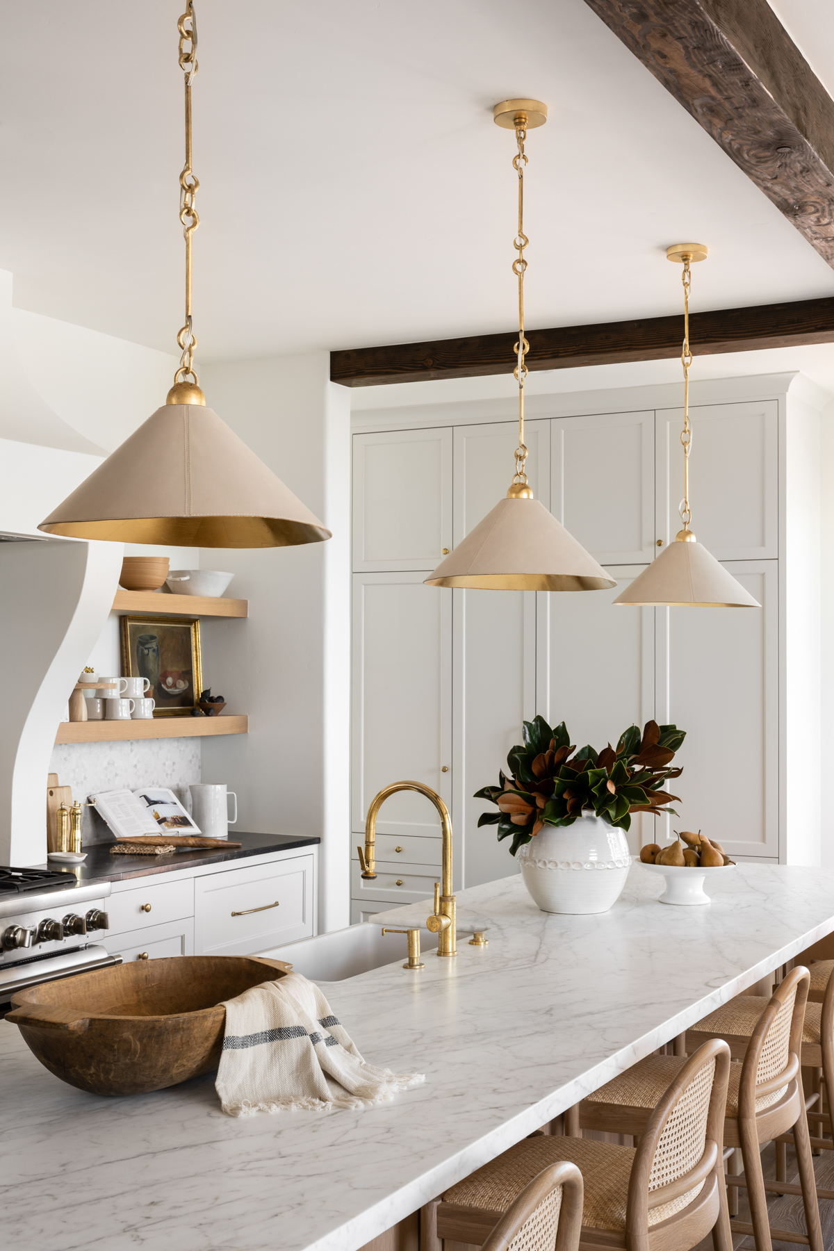 white kitchen with white leather pendants over kitchen island with dough bowl