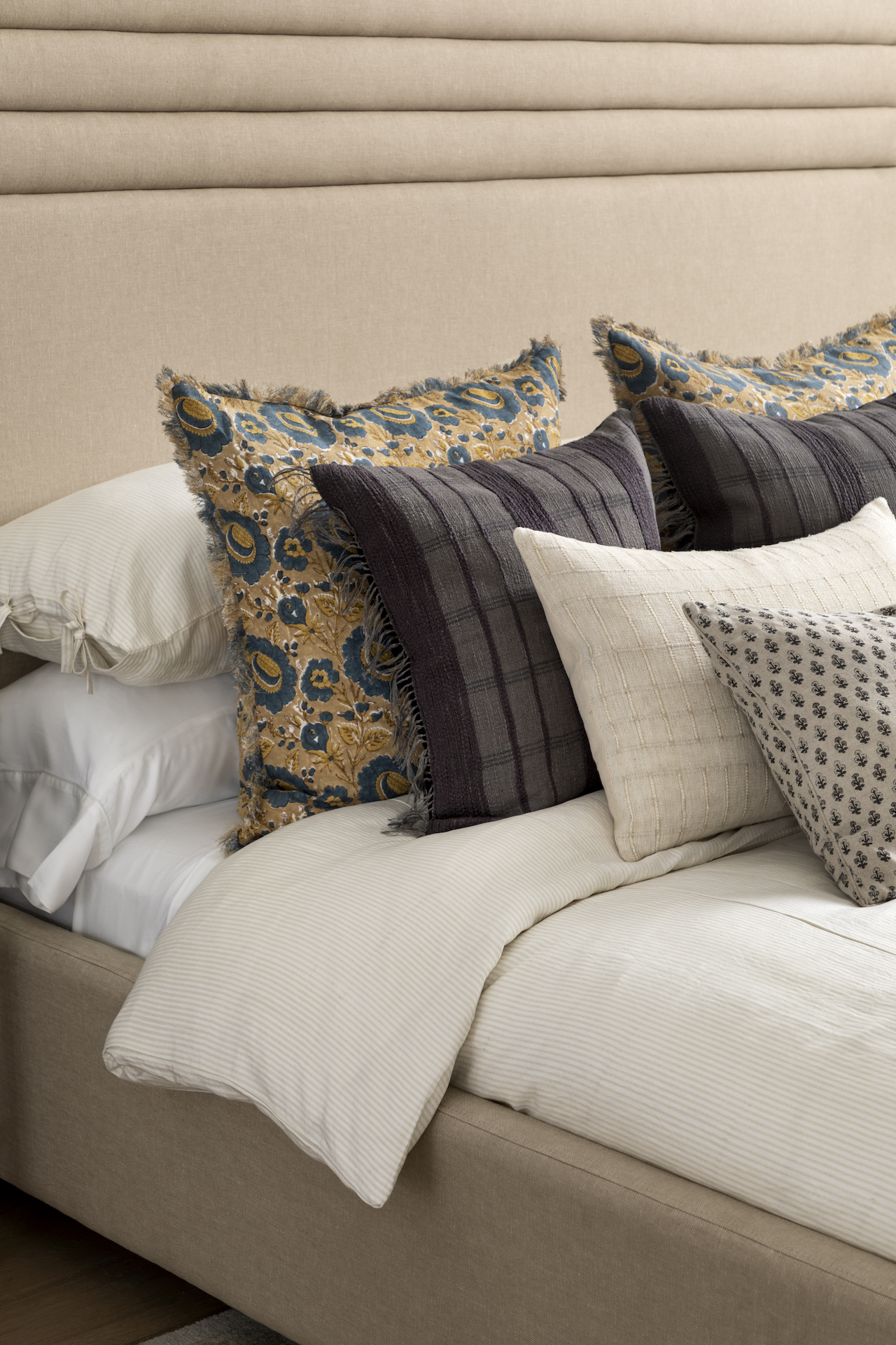 Upholstered bed with a mix of patterned pillows