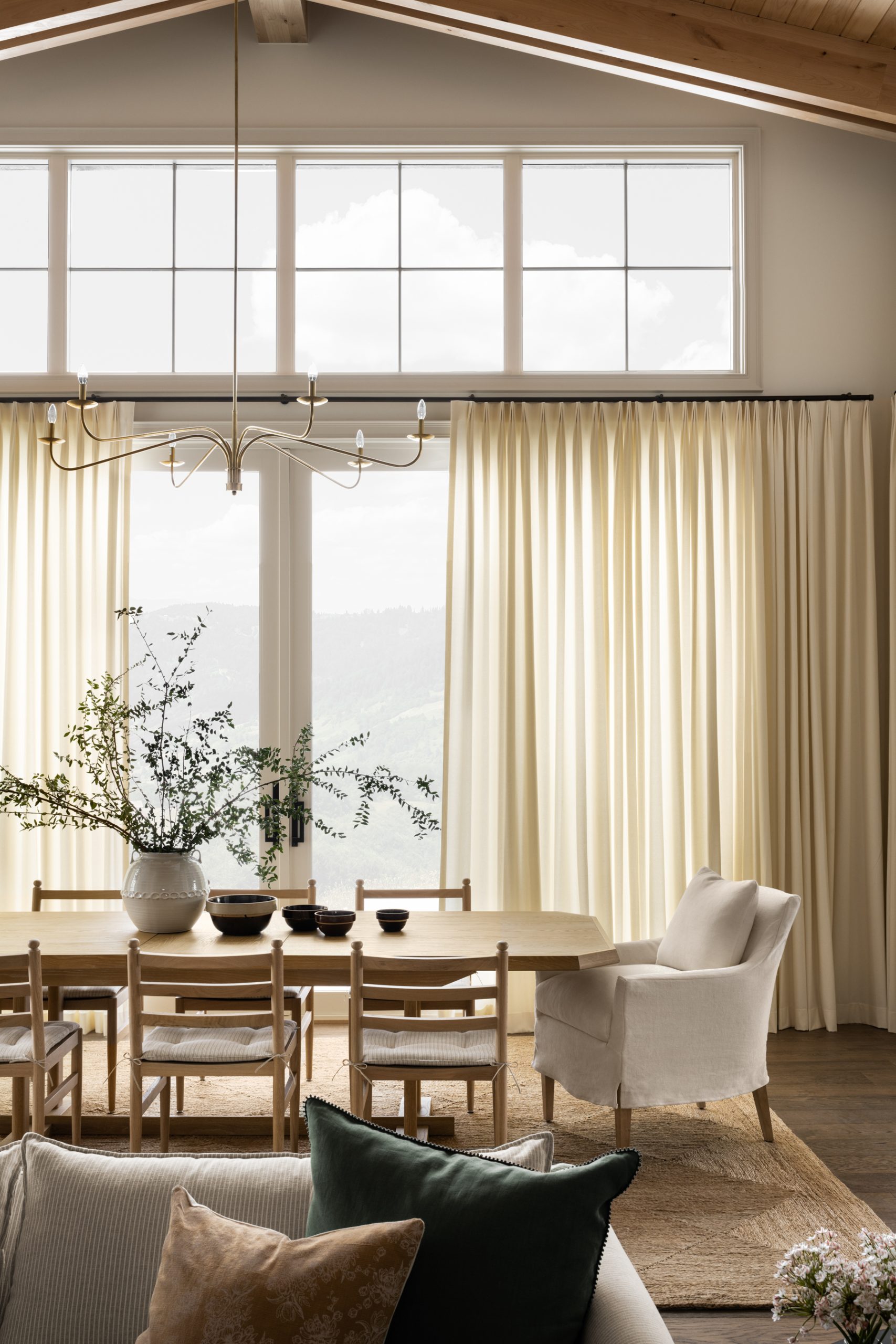 dining room with wood dining table and chairs with large windows and drapes