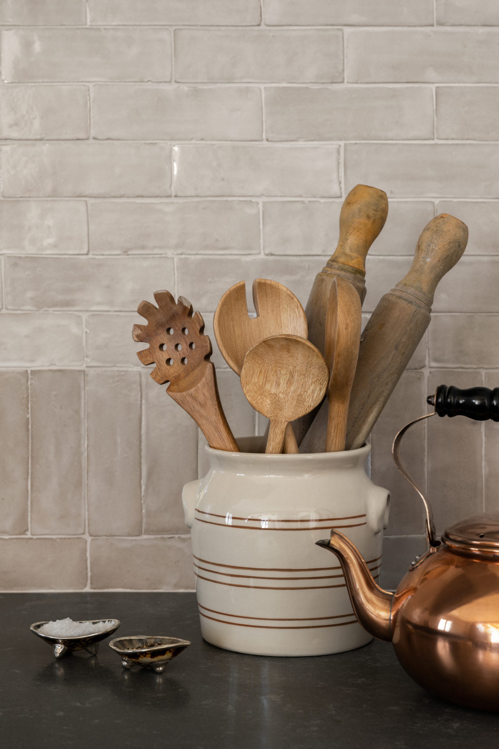 Ceramic crock holding wooden kitchen utensils