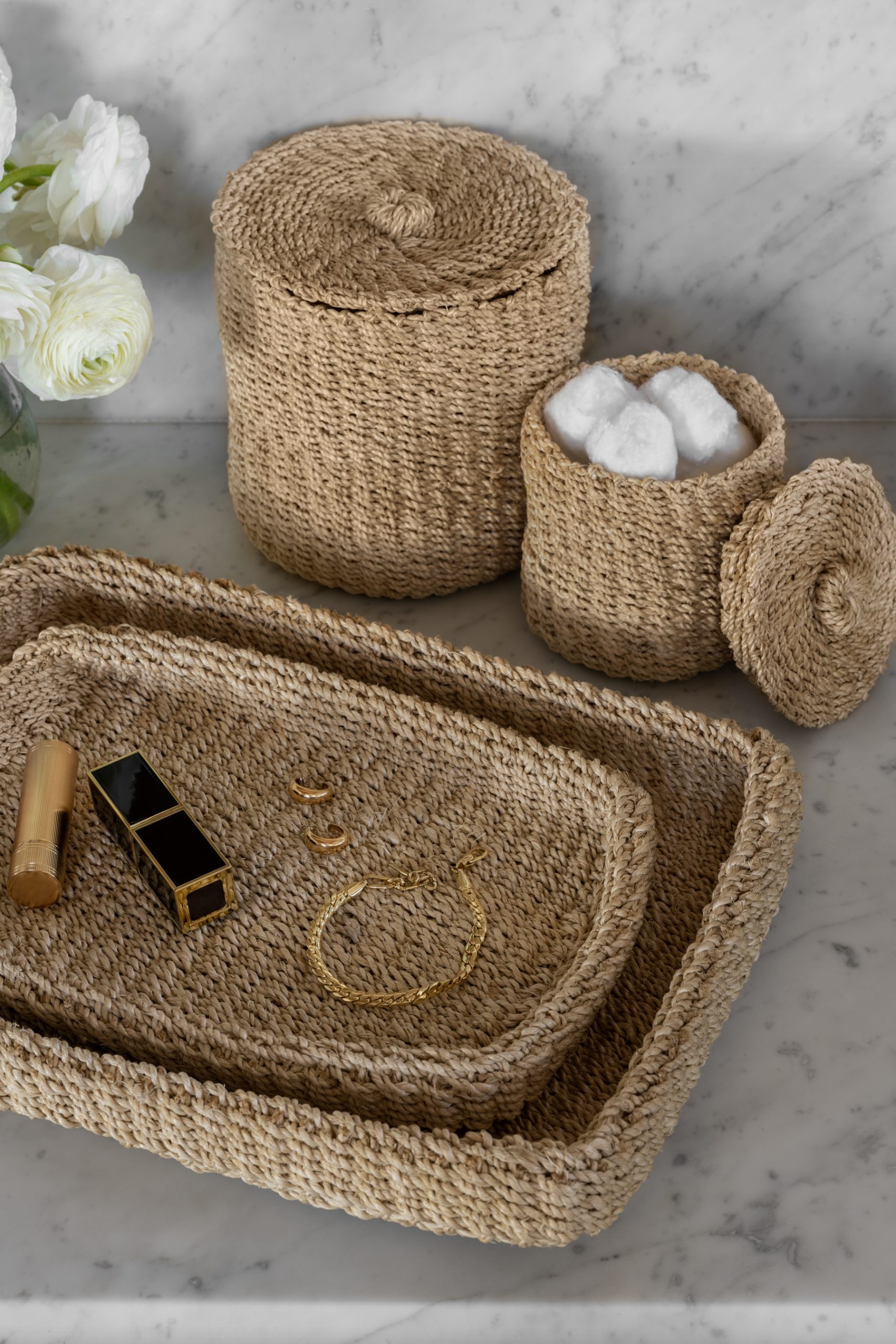 woven tray and canisters on bathroom countertop