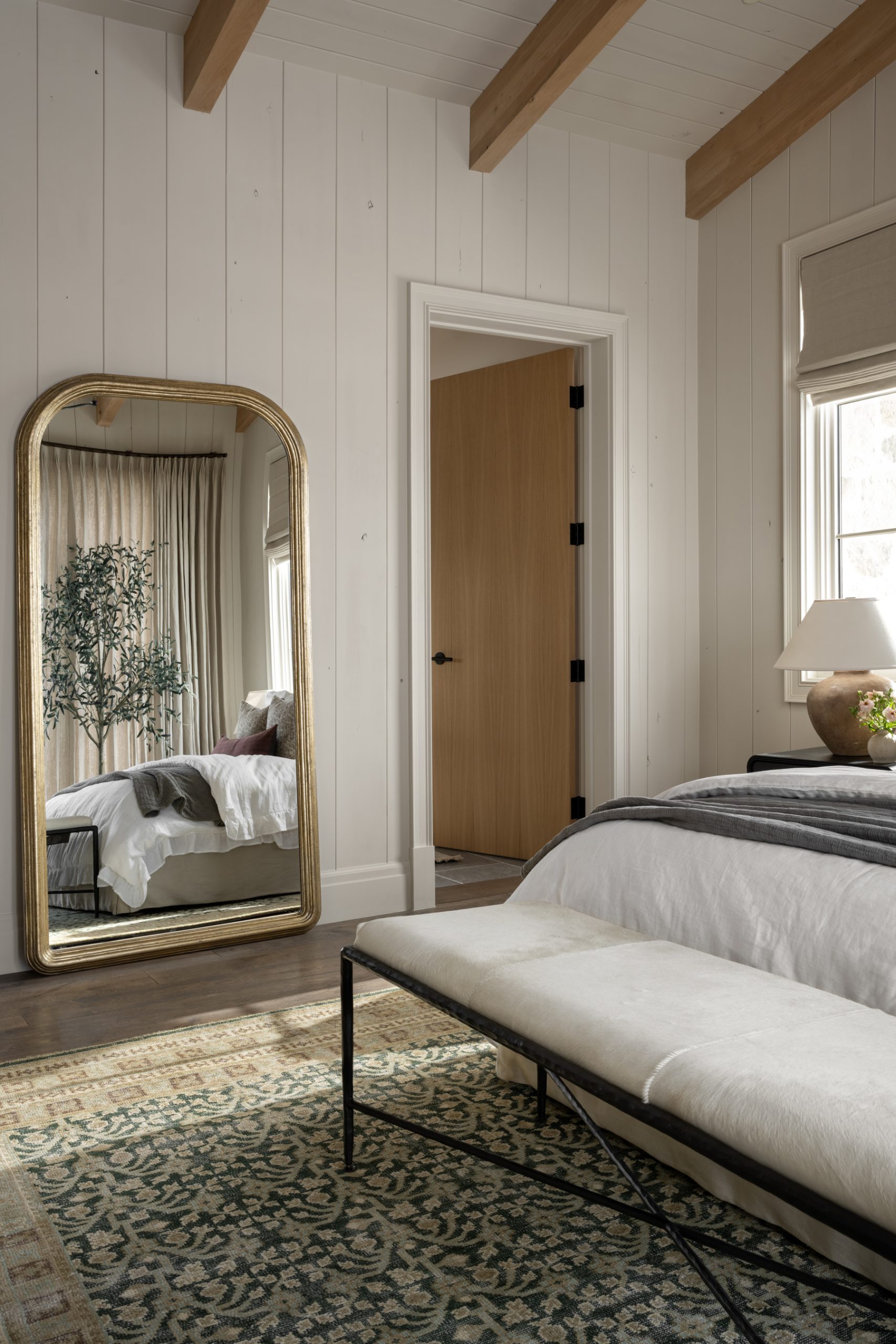 bedroom with brass floor mirror