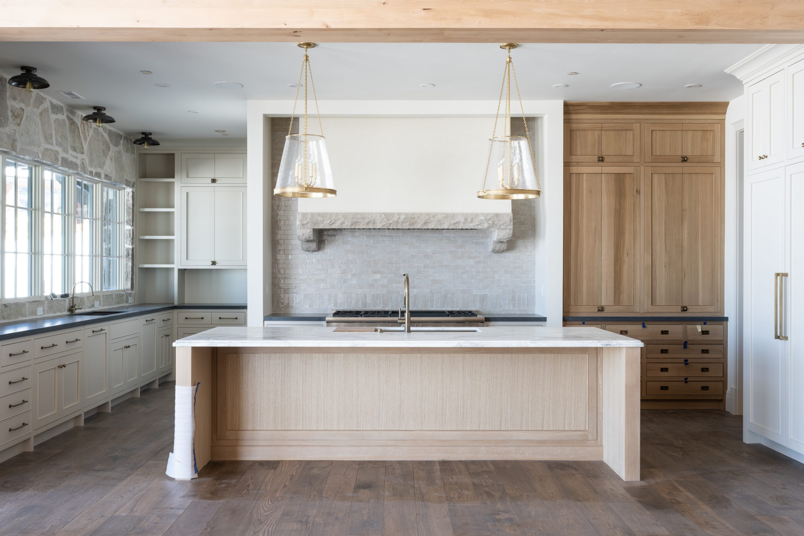 kitchen with natural wood island and built-in cabinet with white cabinets and marble countertops