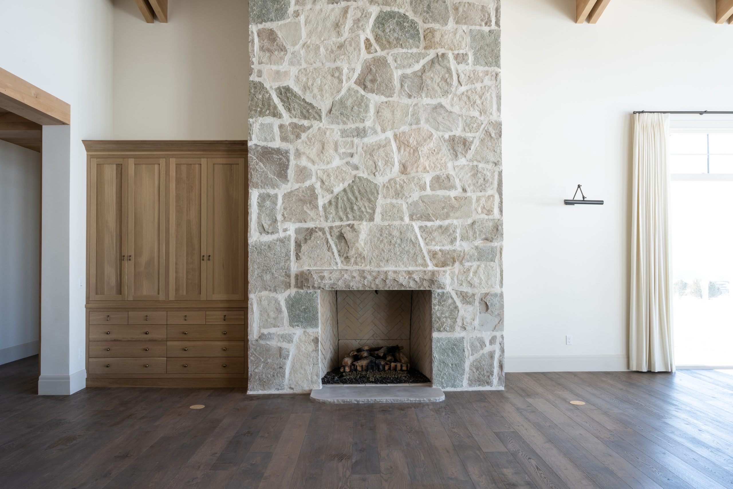 living room with stone fireplace and natural wood built-in cabinet
