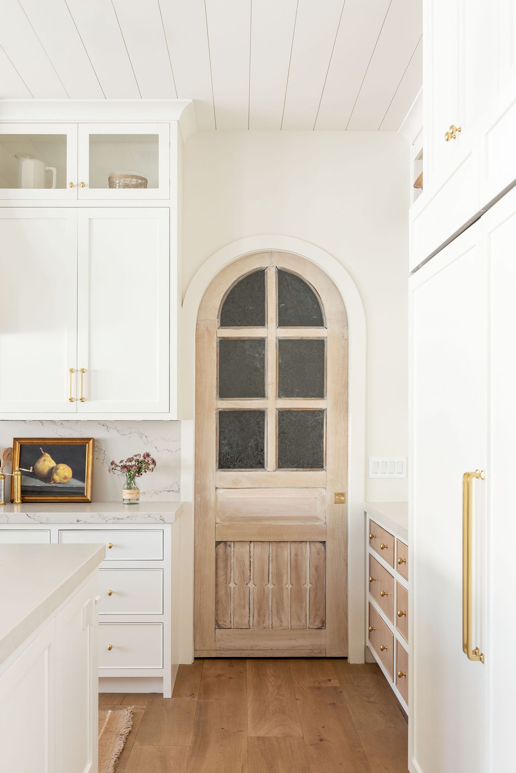 white kitchen with arched pantry door