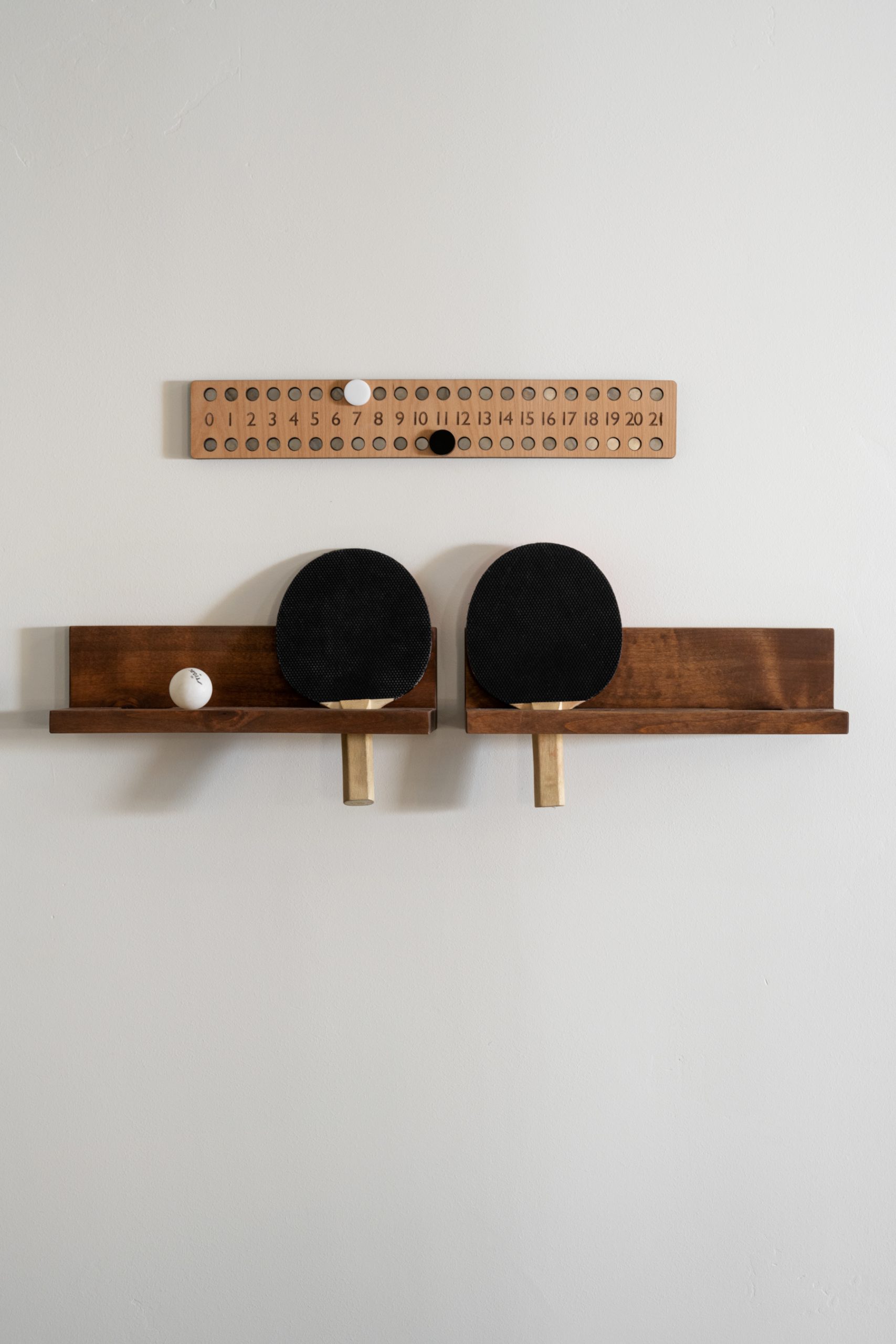 basement with shelf holding ping pong paddles