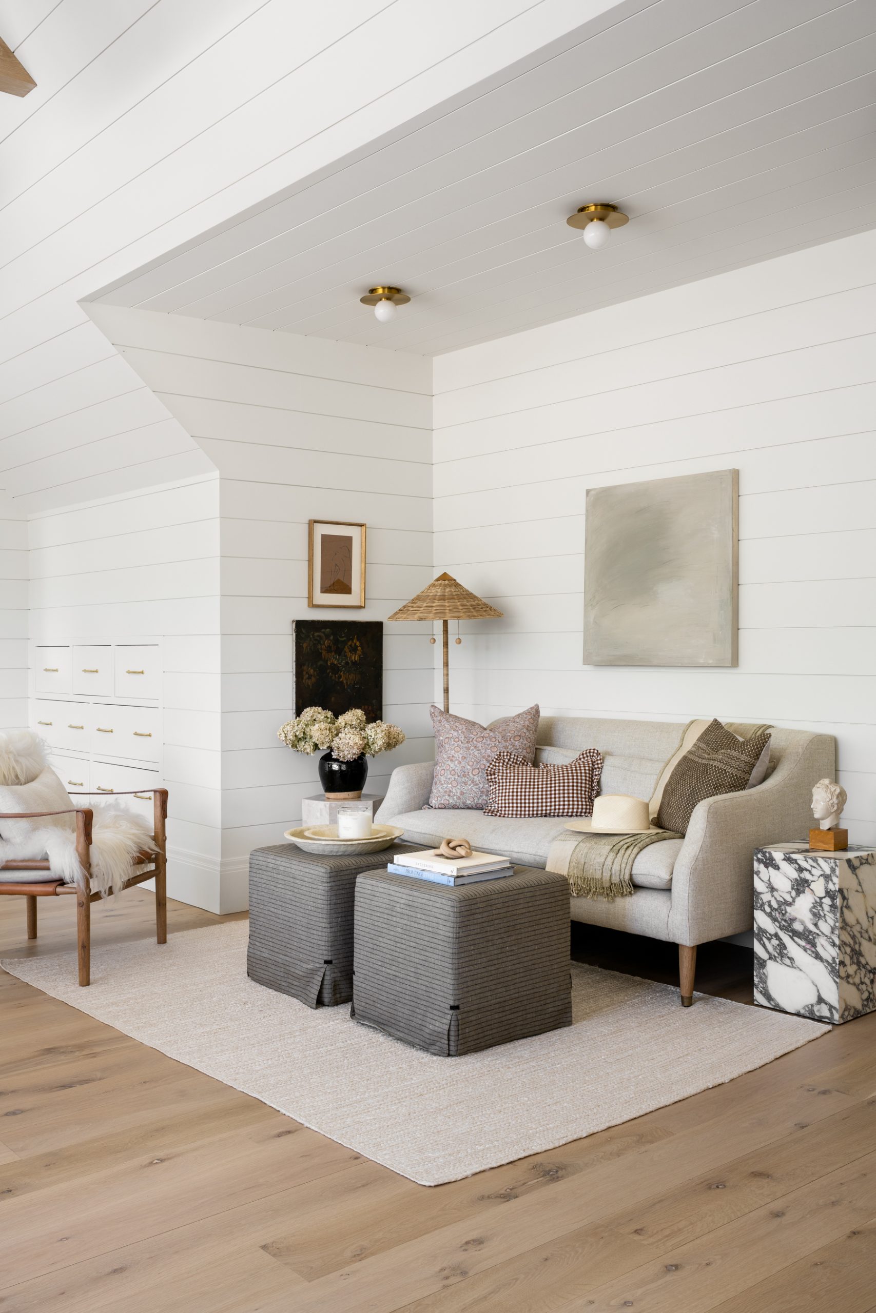 sitting area with sofa and white shiplap wall treatment