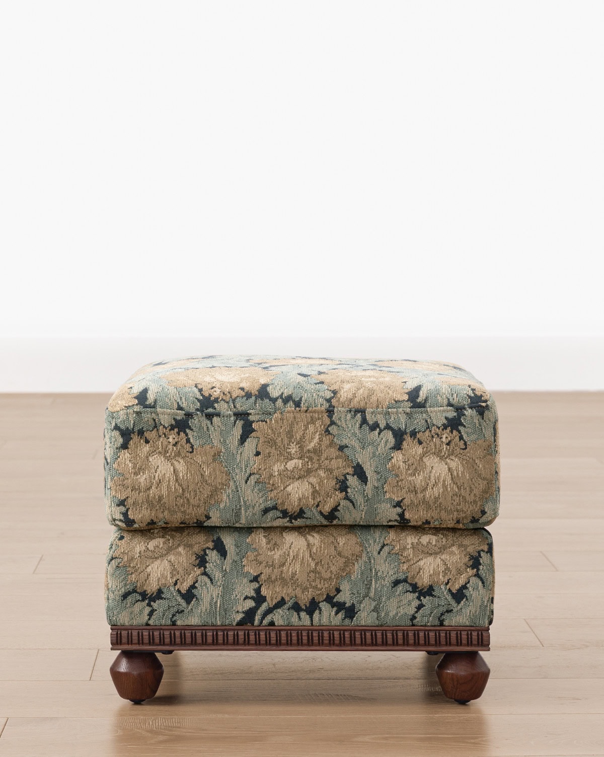 Beautiful carved wood base compliments the blue and beige floral upholstery, the Catherine Ottoman pulls in a tapestry appeal, perfect for living room decor from Studio McGee.
