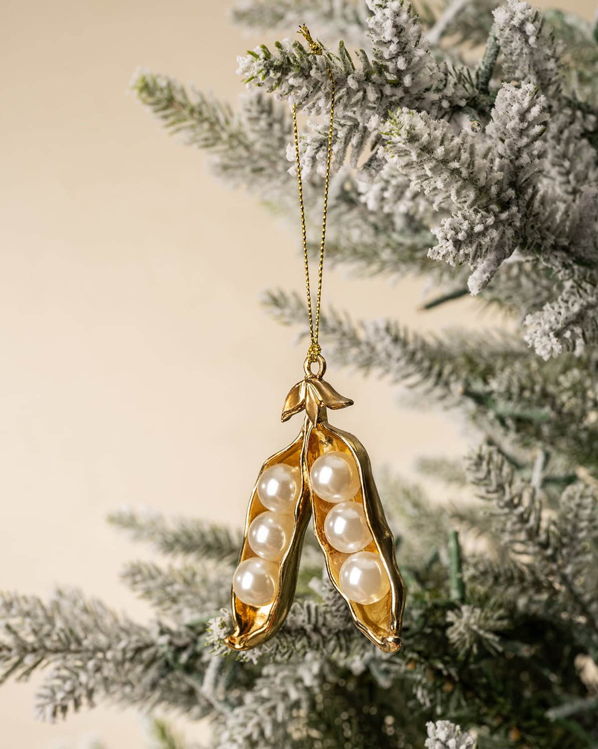 A gorgeous Christmas tree ornament, features 6 pearl beads in golden pea gods, hanging from a gold string from Studio McGee.