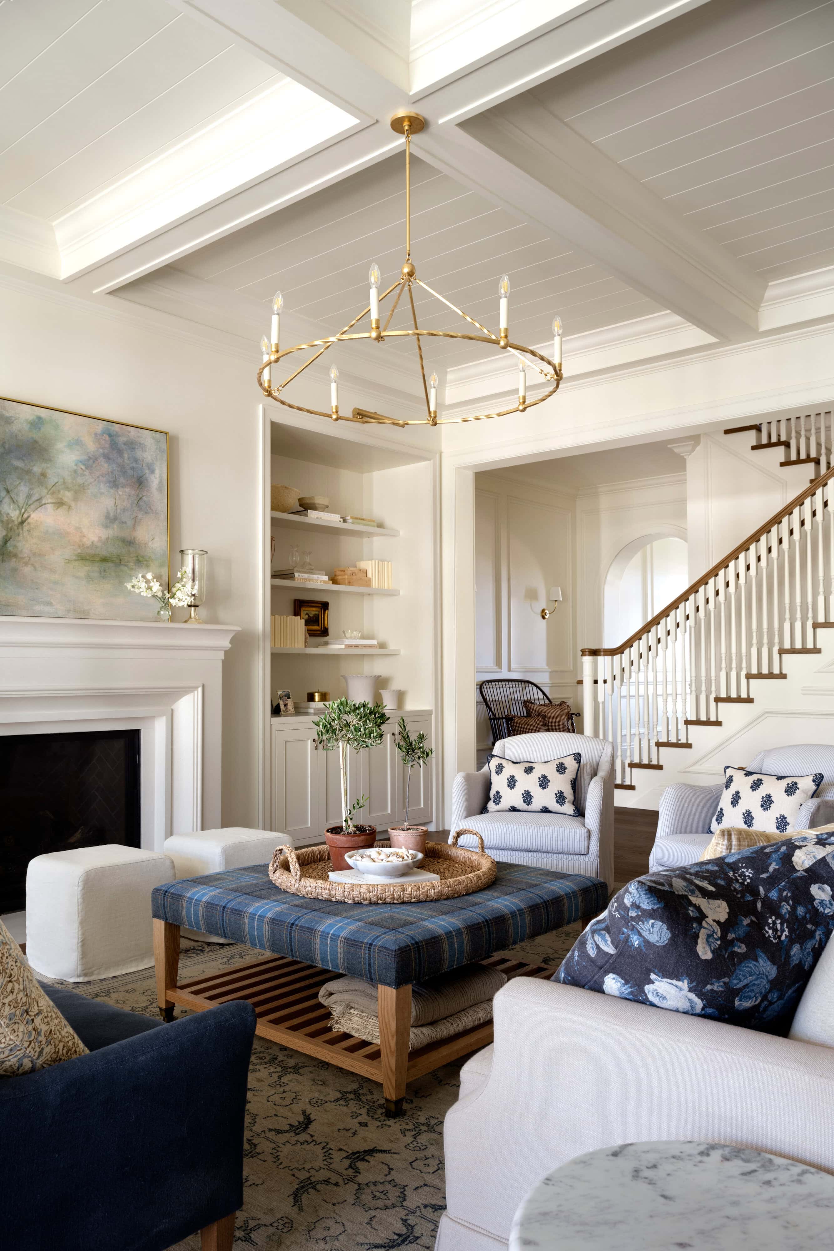 A living room with a fireplace and a chandelier, by McGee & Co.