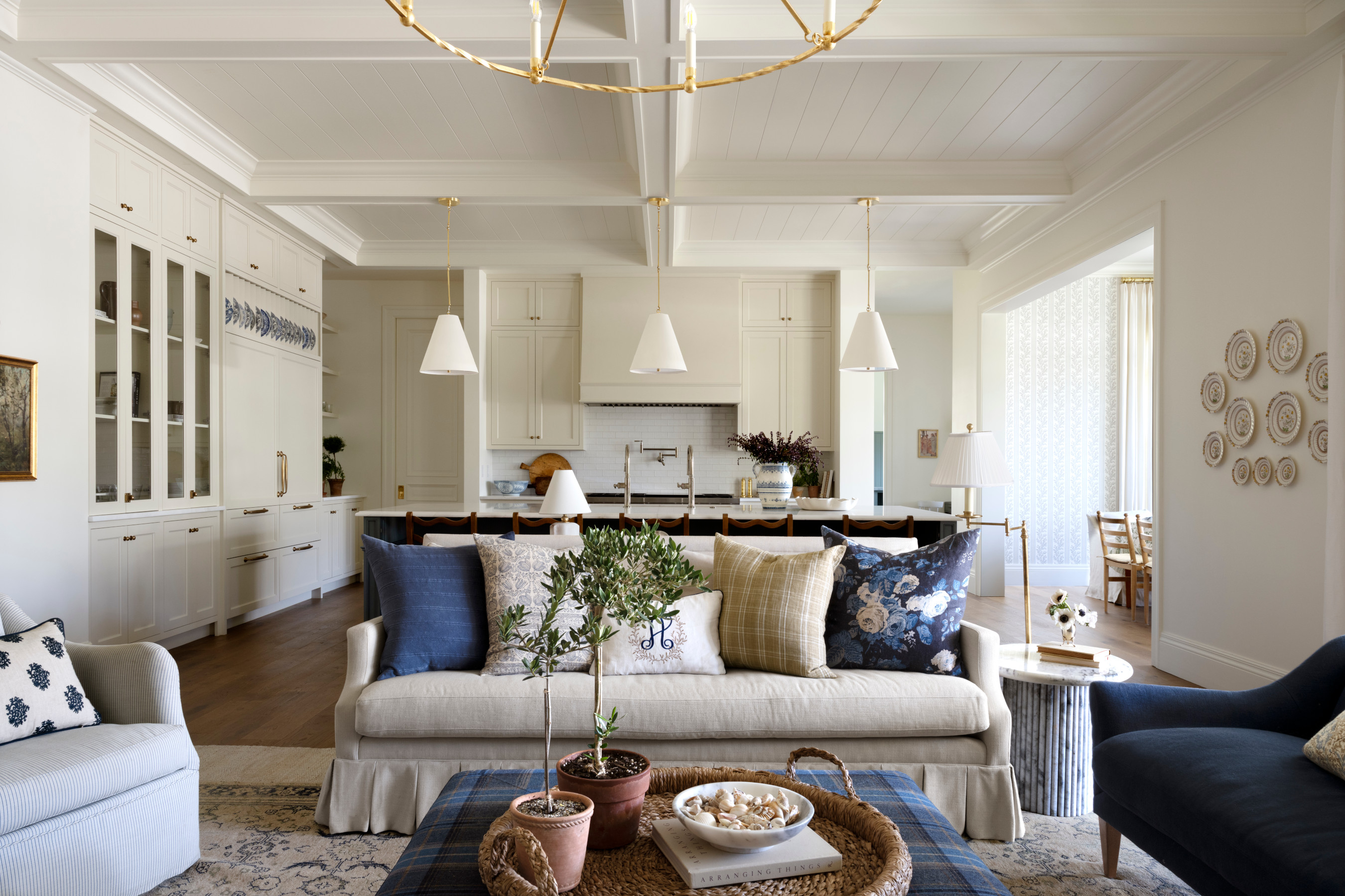 A living room with a couch and a kitchen, by McGee & Co.