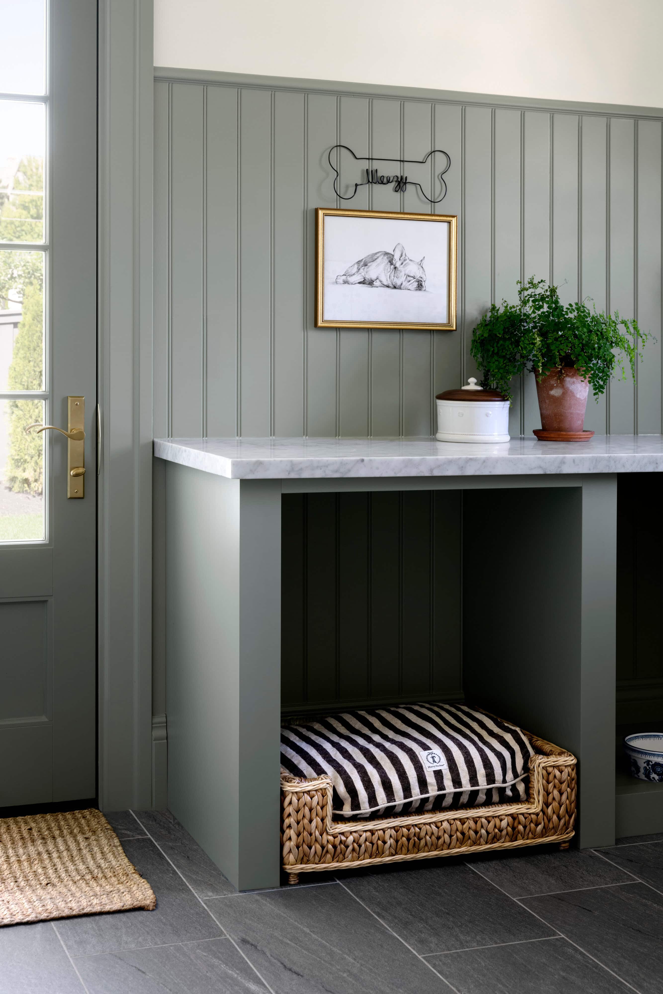 A marble counter top with a striped cushion and potted plants on it, by McGee & Co.