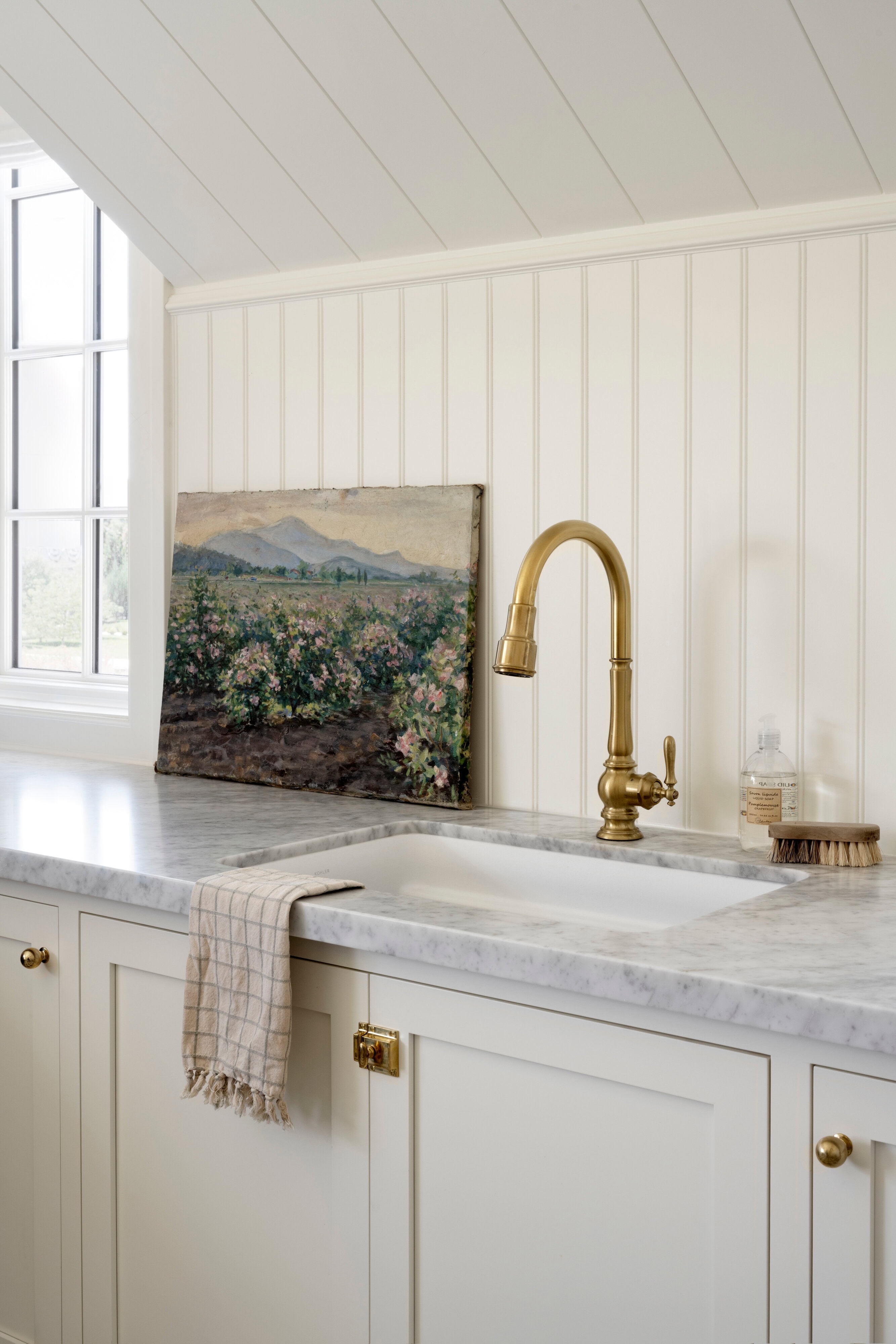 A sink and painting on the wall, by McGee & Co.