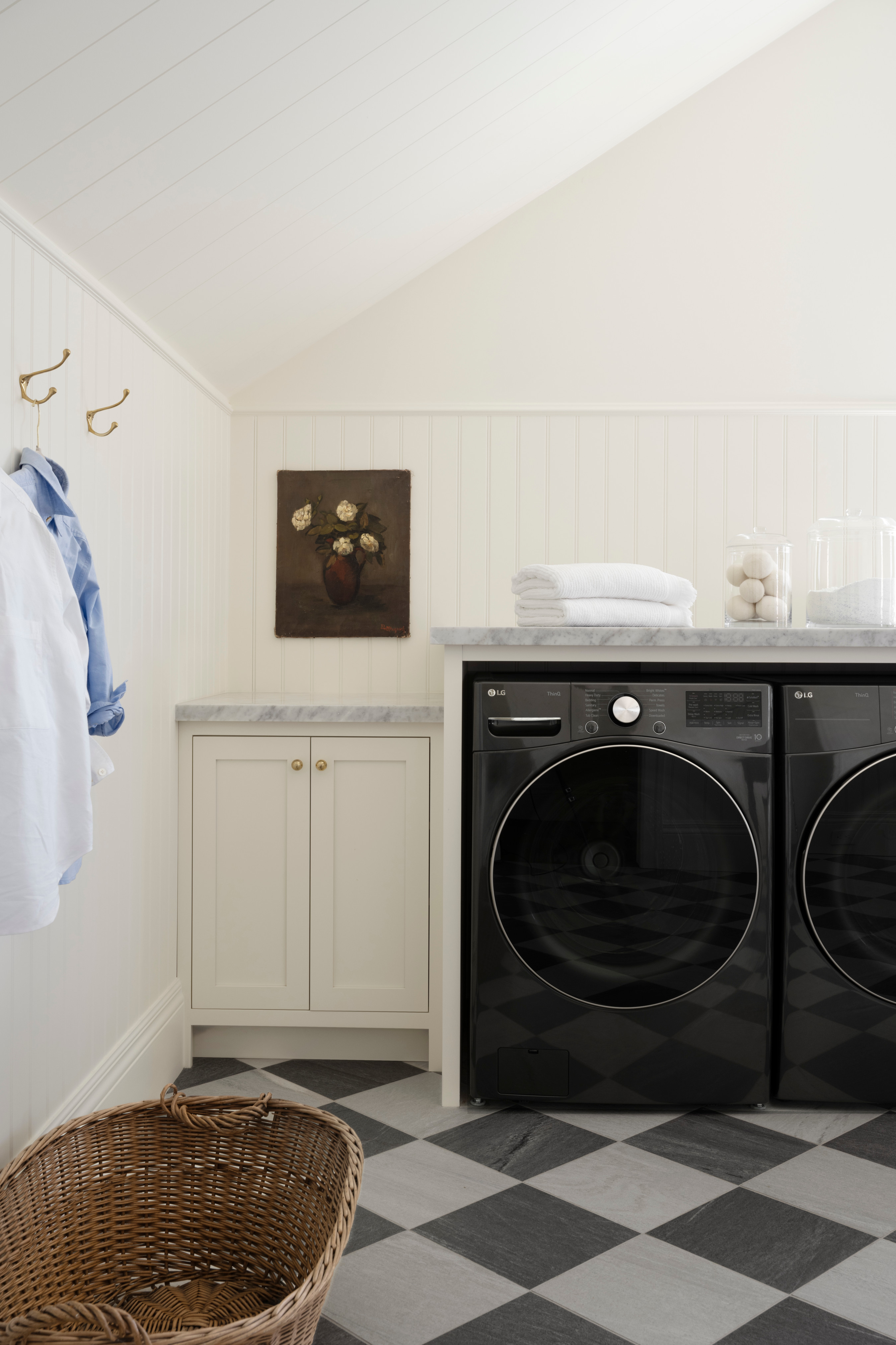 A washer and dryer in a laundry room, vintage-style design with a checkered floor from Studio McGee.